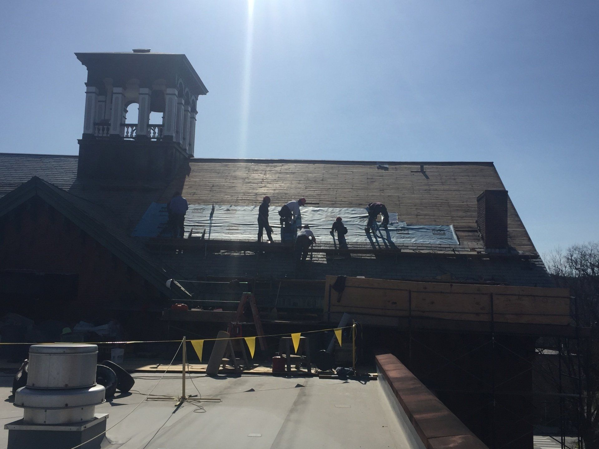 A group of people are working on the roof of a building.