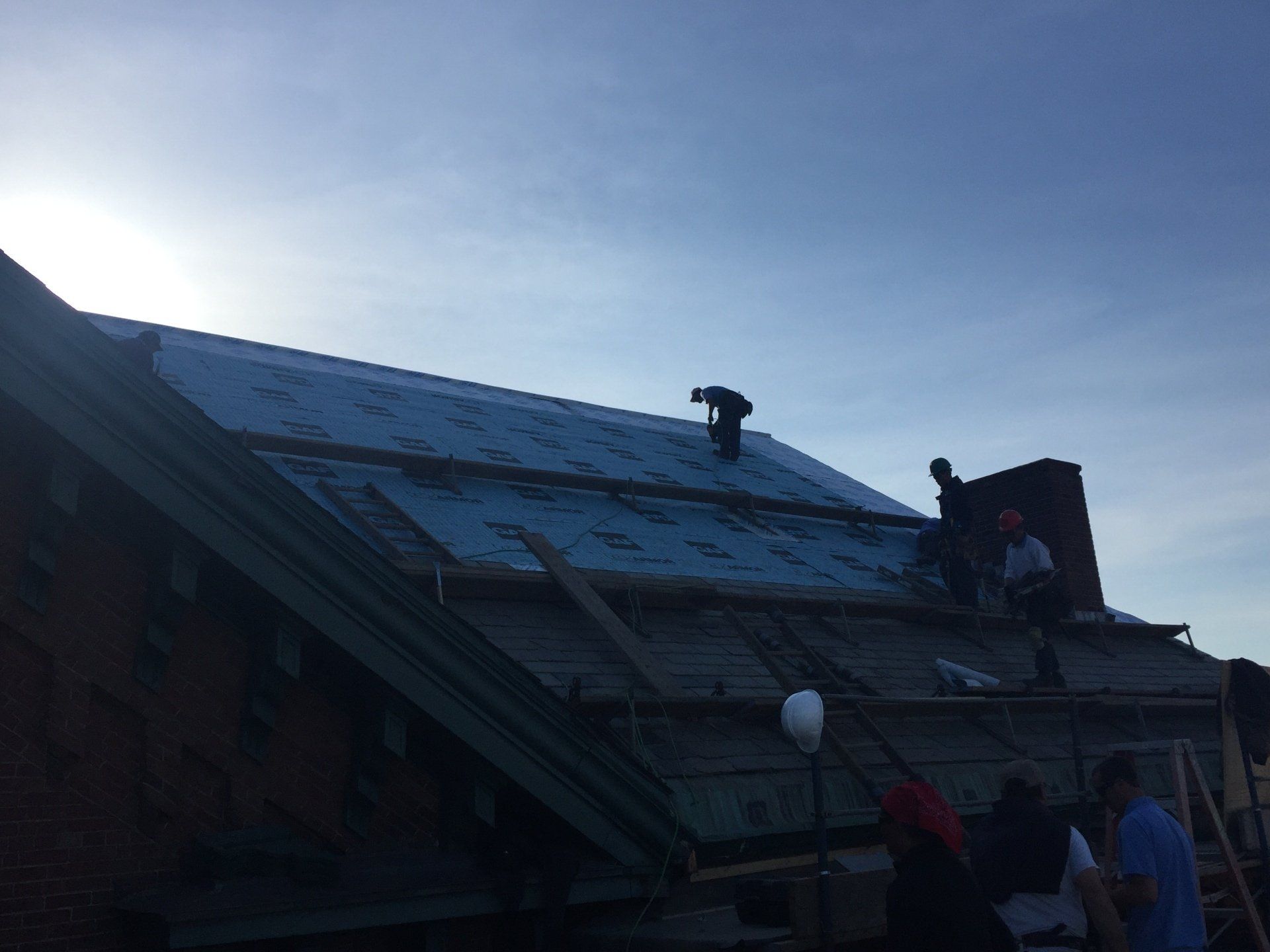 A group of people are working on the roof of a building.