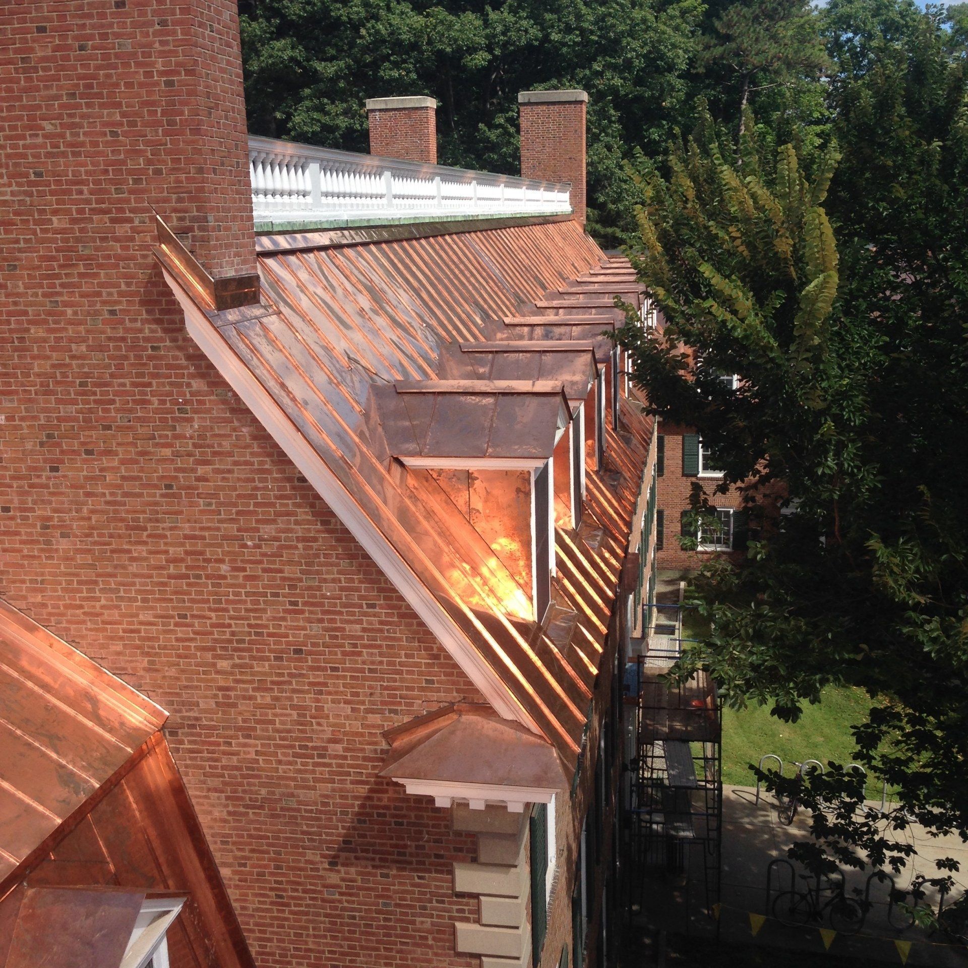 A brick building with a copper roof and chimneys