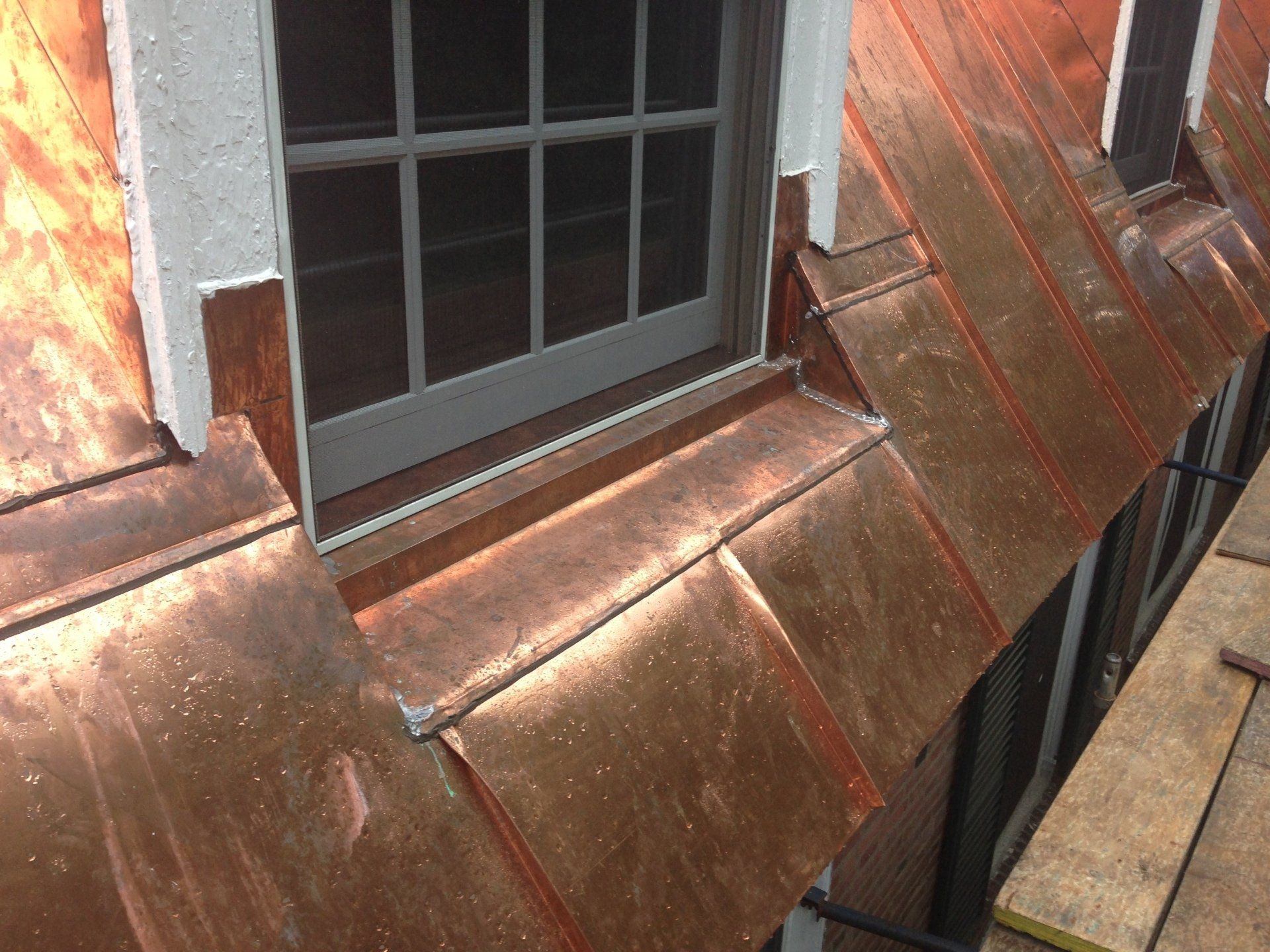 A window on a building with a copper roof