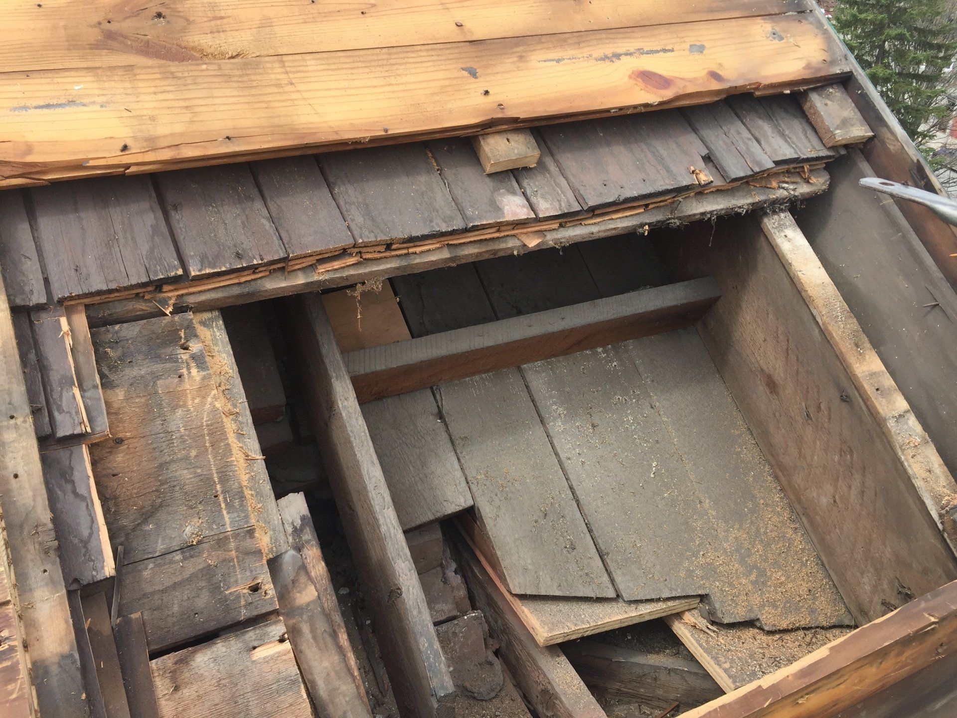 A wooden box is sitting on top of a wooden roof.