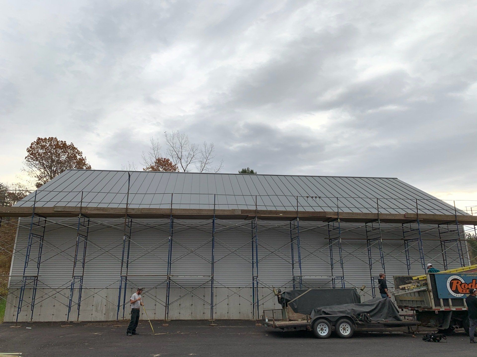 A man is standing in front of a building under construction.