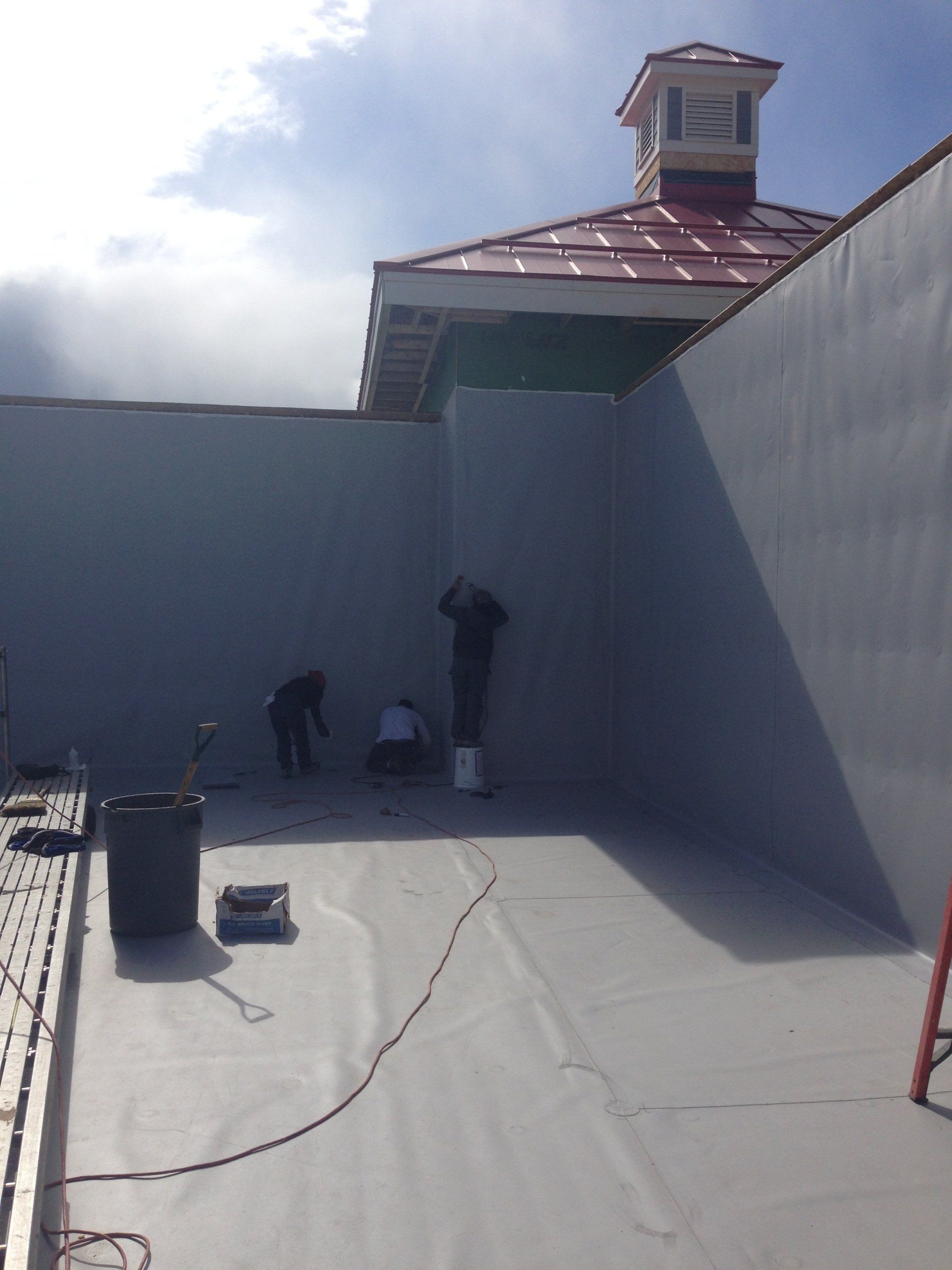 A building with a red roof is being painted