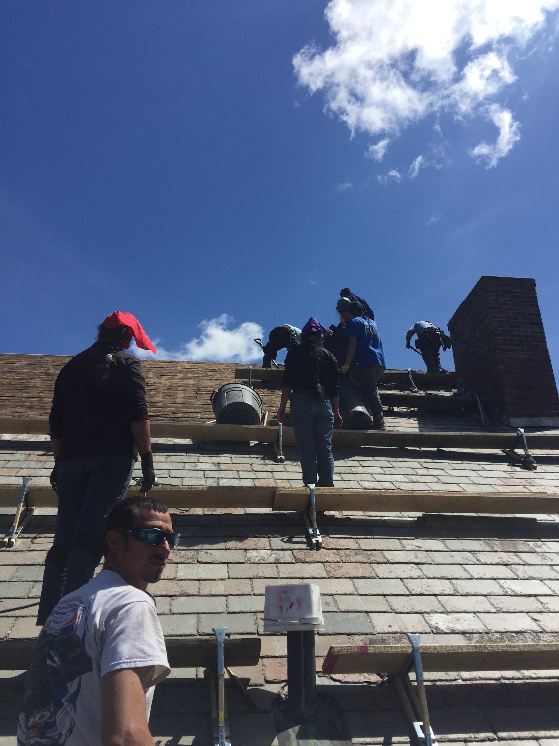 A group of men are working on the roof of a building