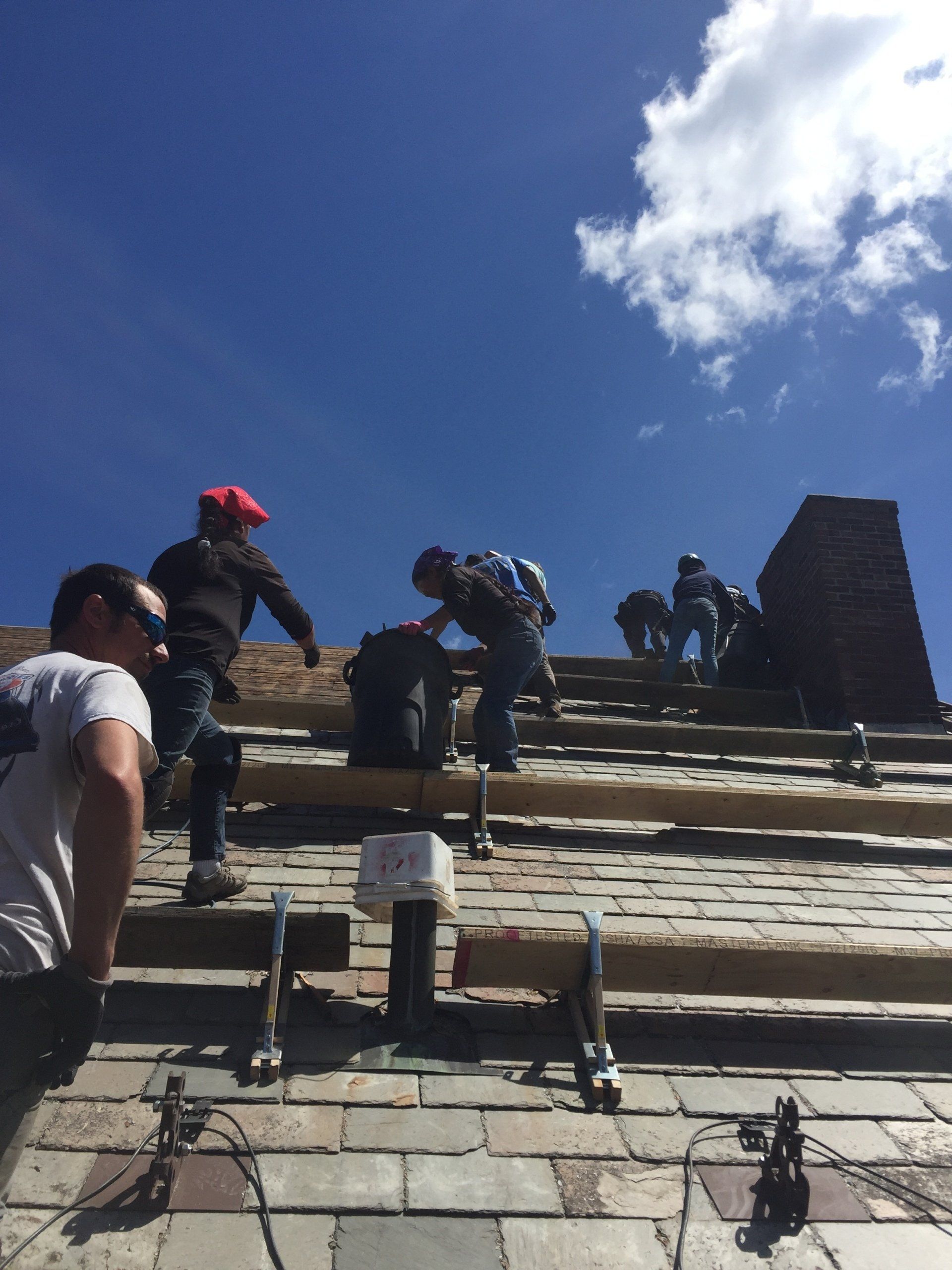 A group of people are working on a brick building