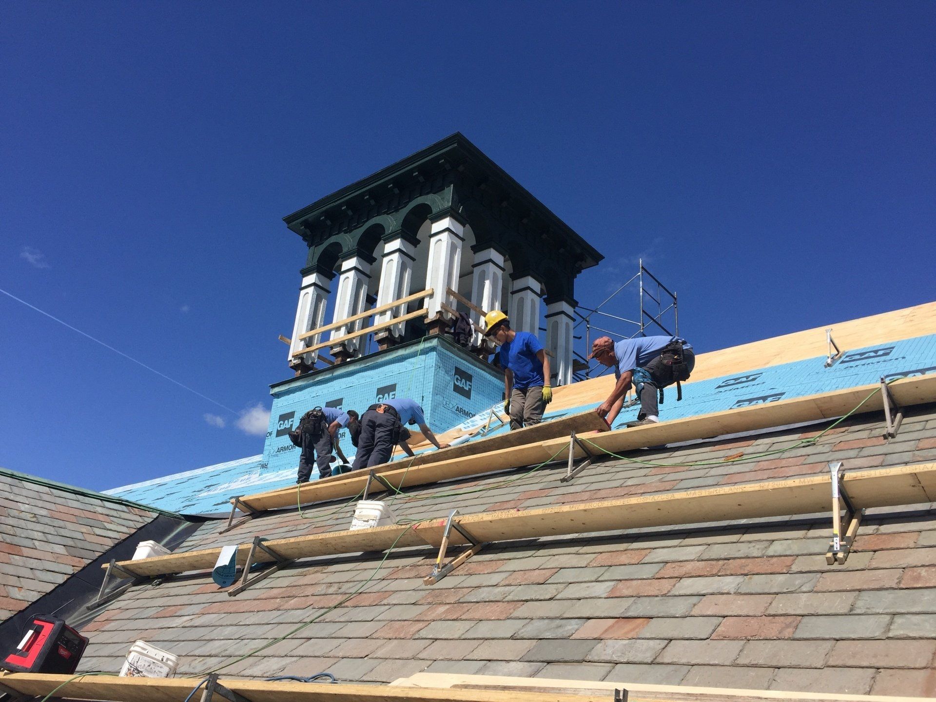 A group of men are working on the roof of a building.