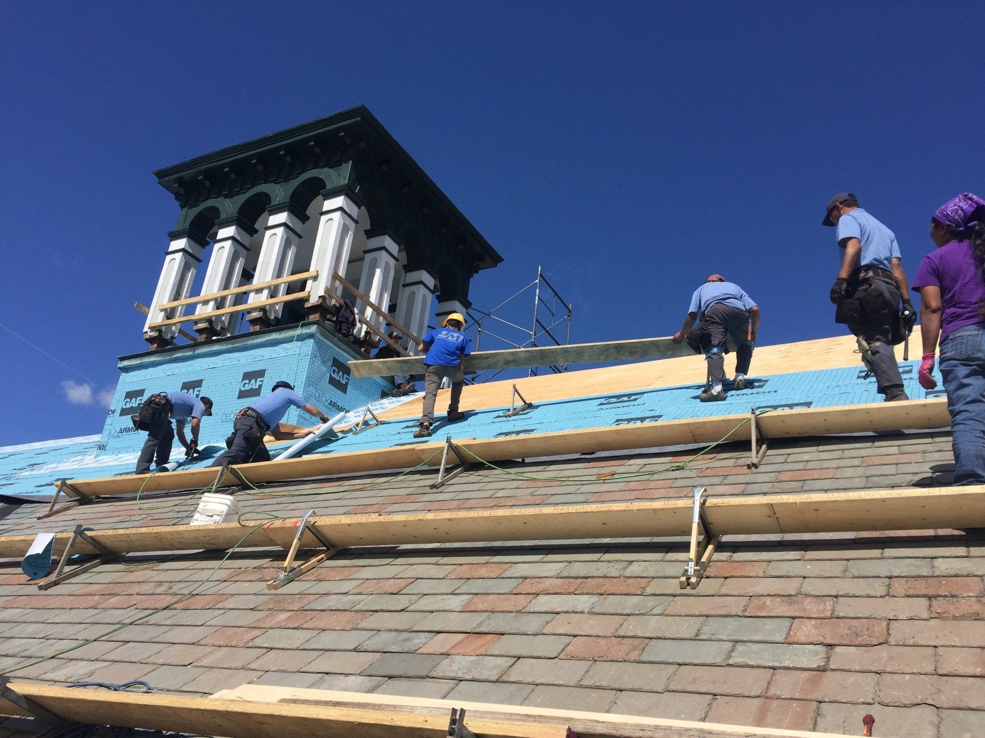 Rodd Roofing employees prepping a commercial roof getting it ready for a new slate roof