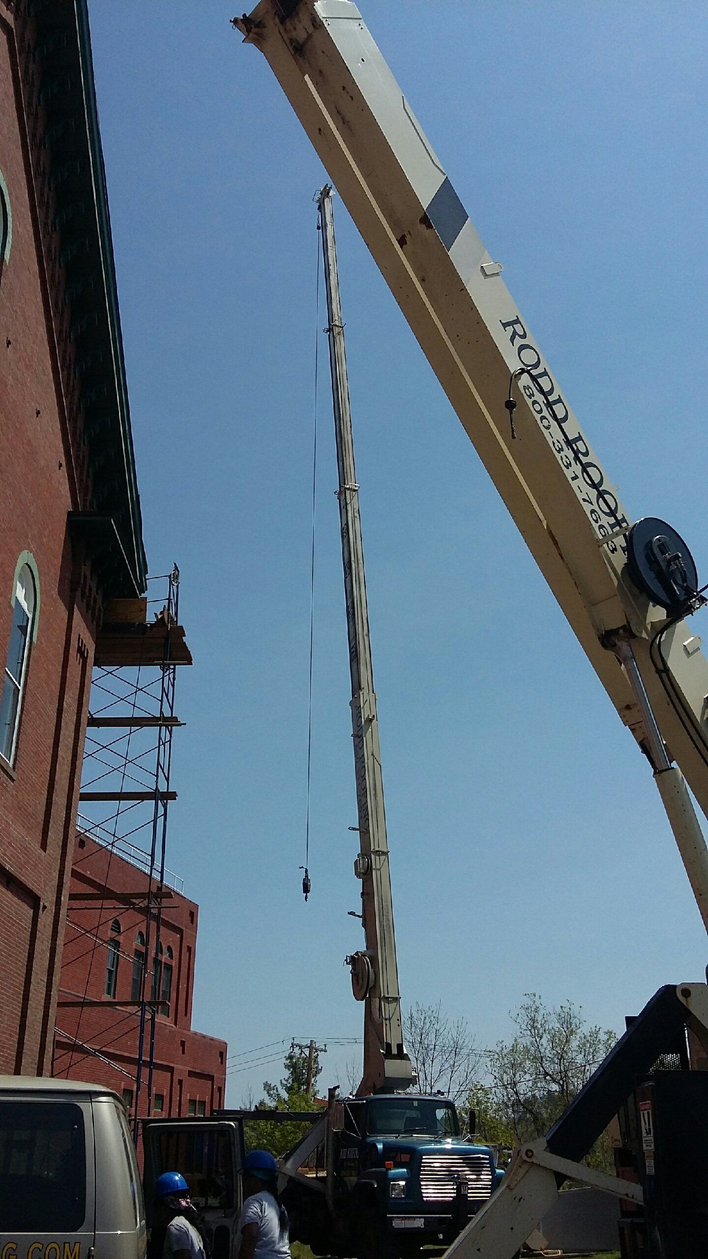 Rodd Roofing  employees preparing a commercial for a slate roof using their crane trucks