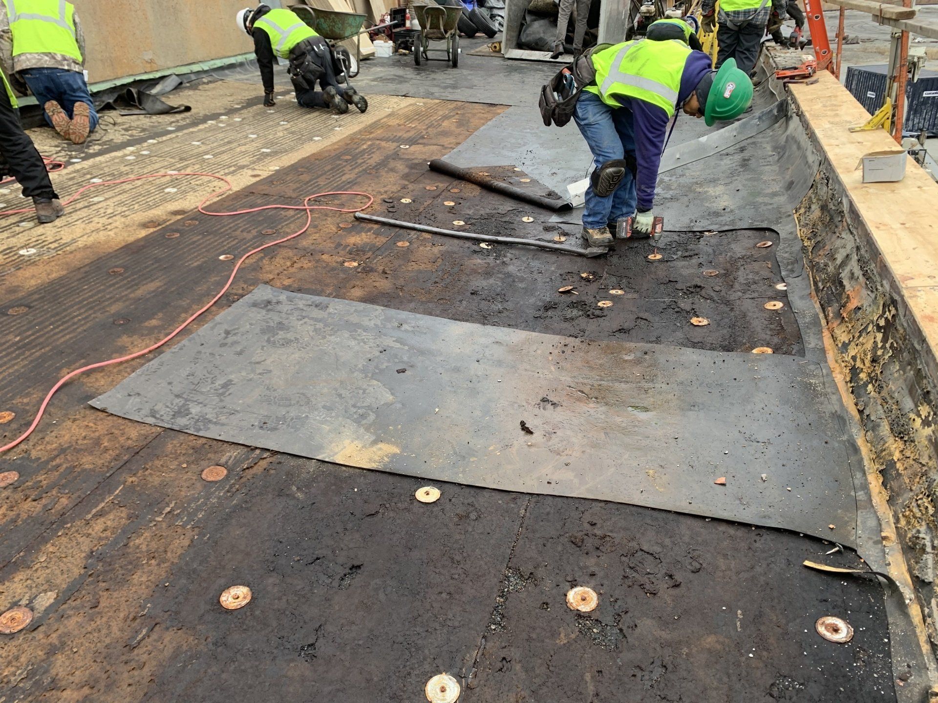 Rodd Roofing employees removing old roofing and laying new roofing