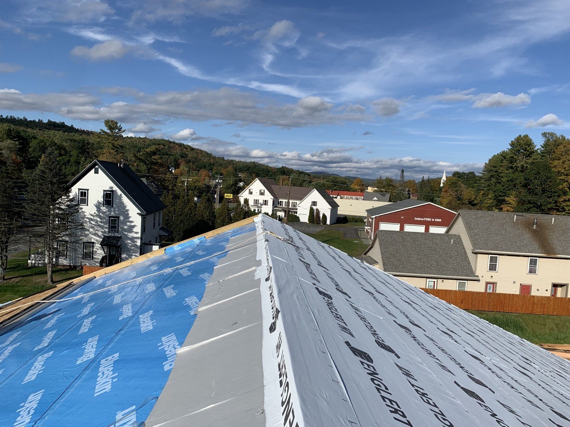 A roof is being installed on a house in a residential area.