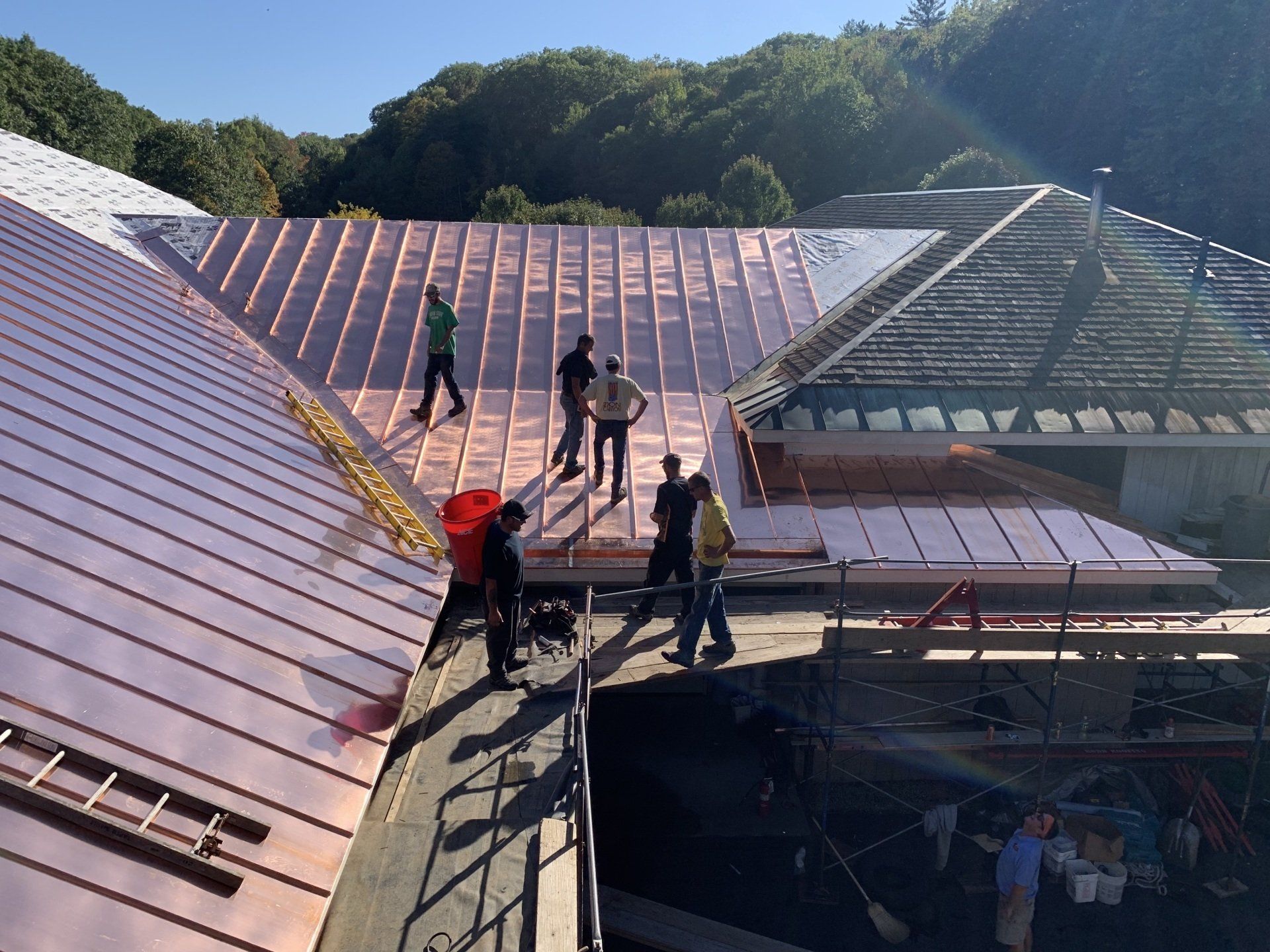 A group of people are working on a copper roof