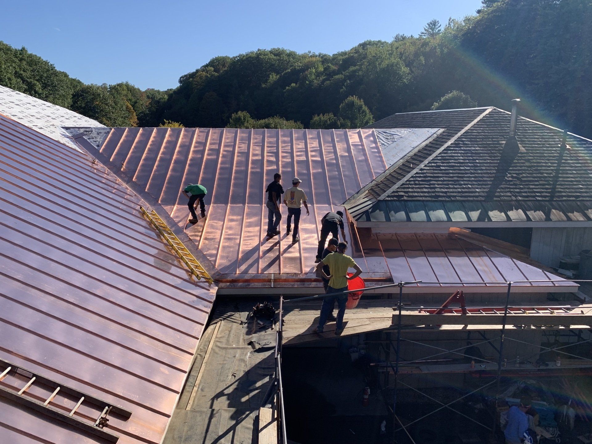 A group of people are working on the roof of a building.