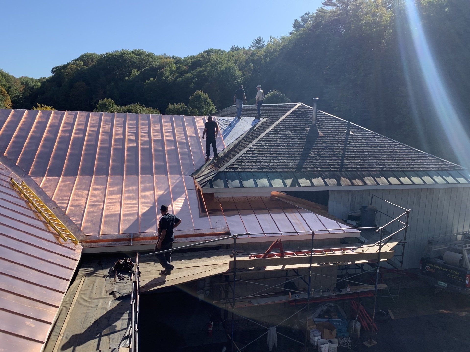 Two men are working on the roof of a house