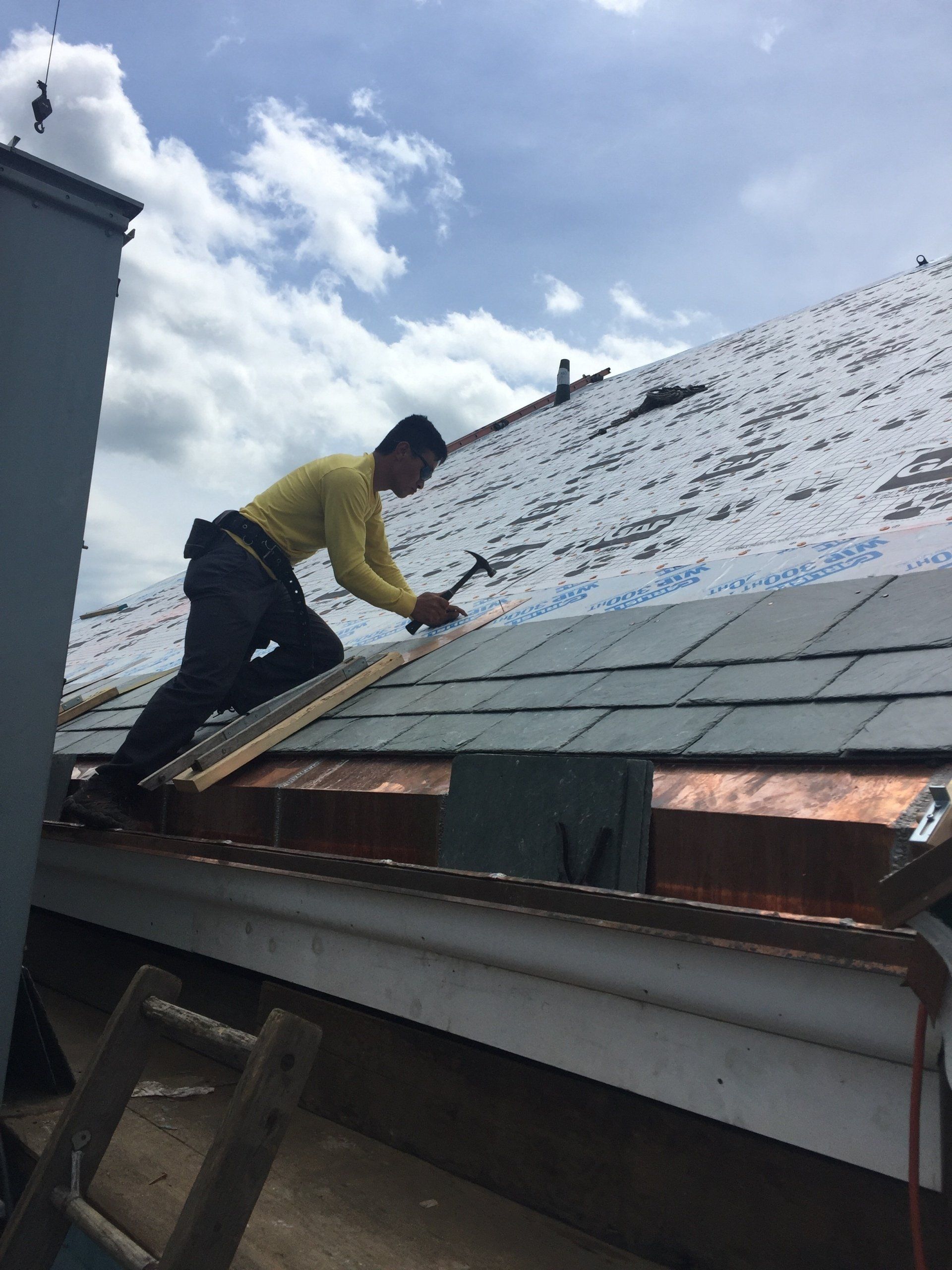 A man is working on the roof of a building
