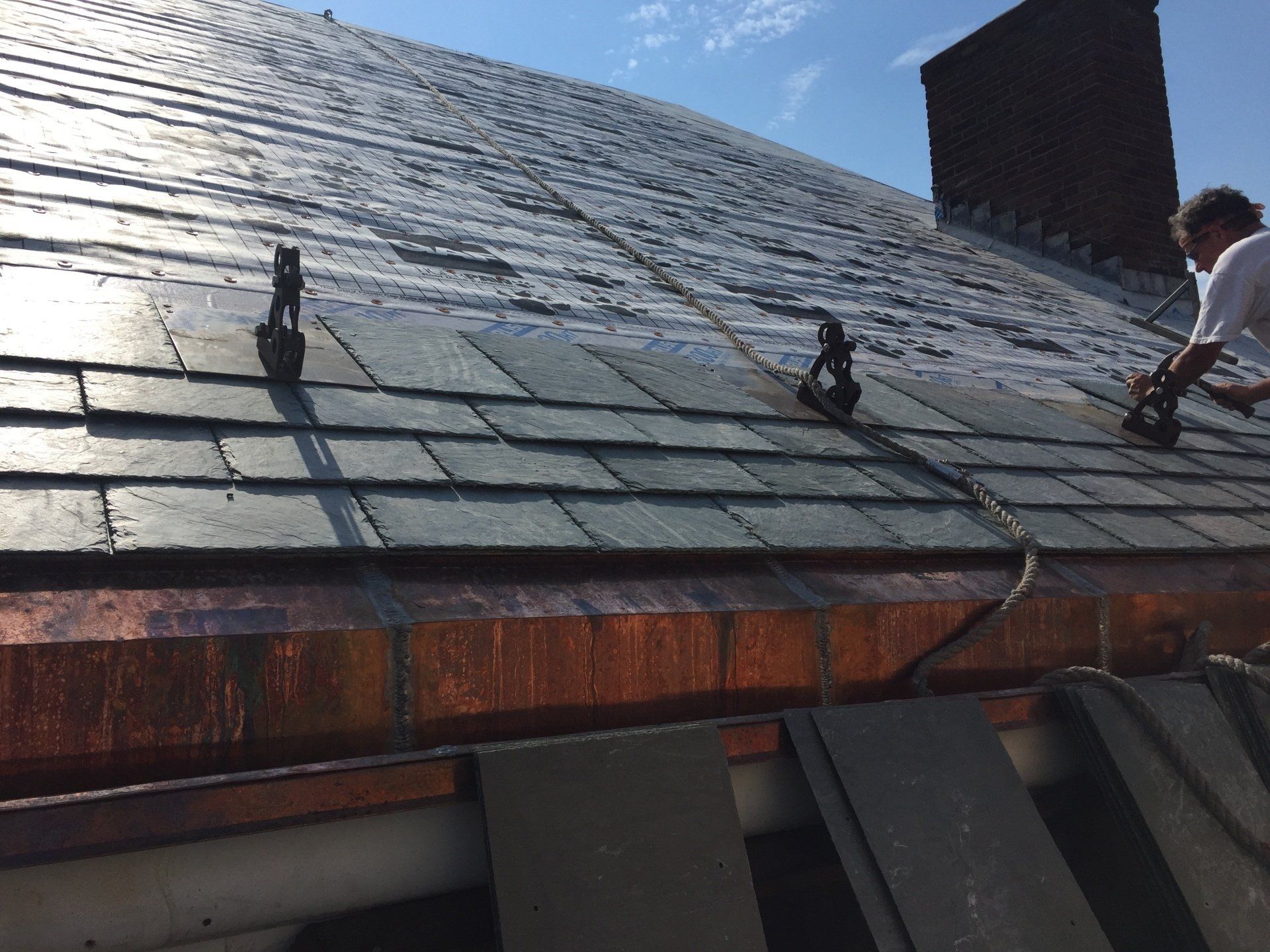 A man is working on the roof of a building.