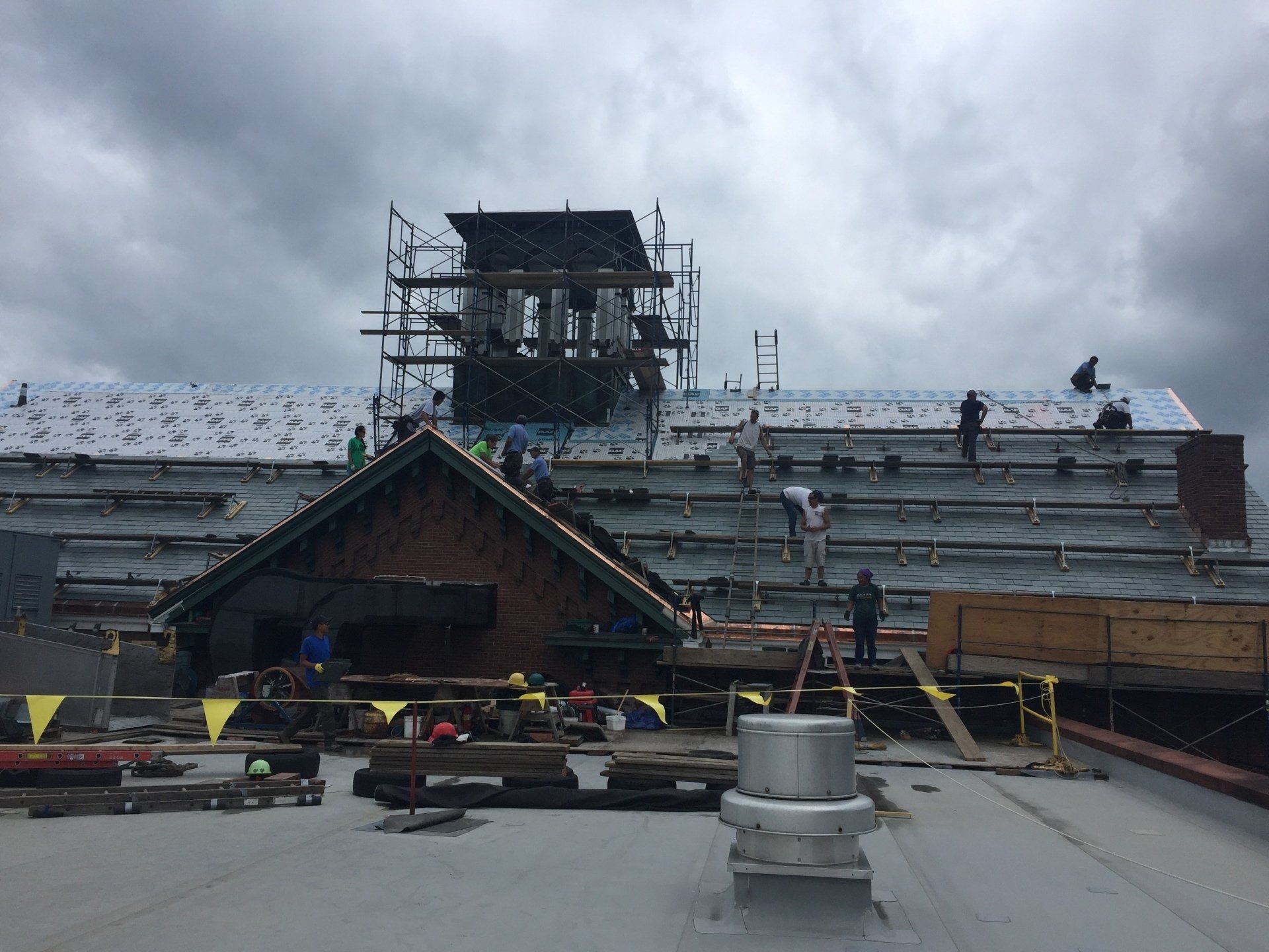 A group of people are working on the roof of a building.