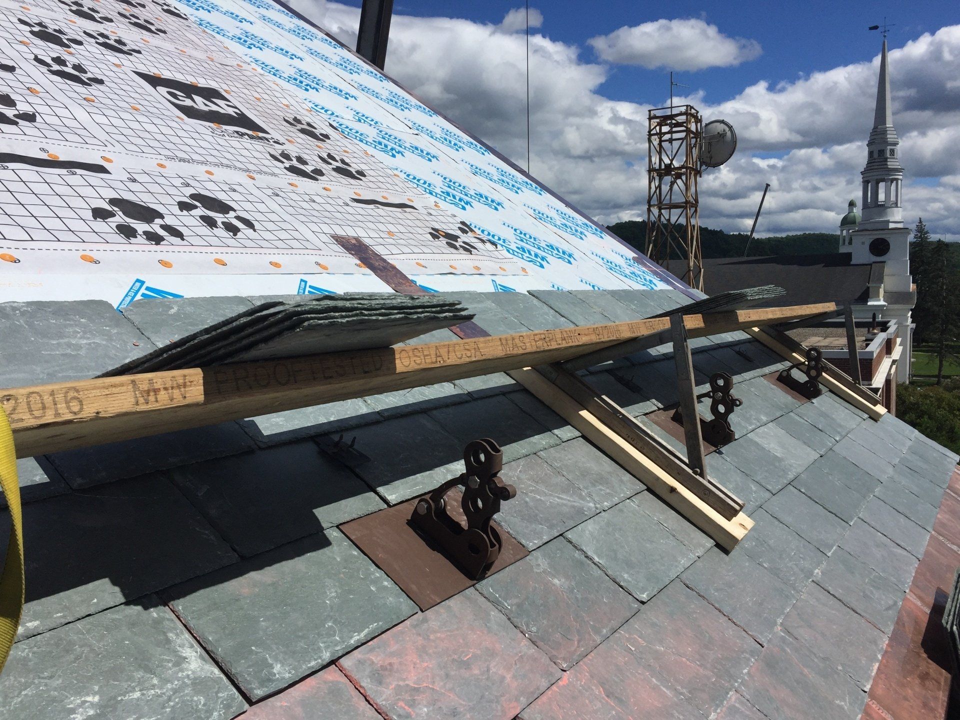 A roof is being built with a crane in the background.