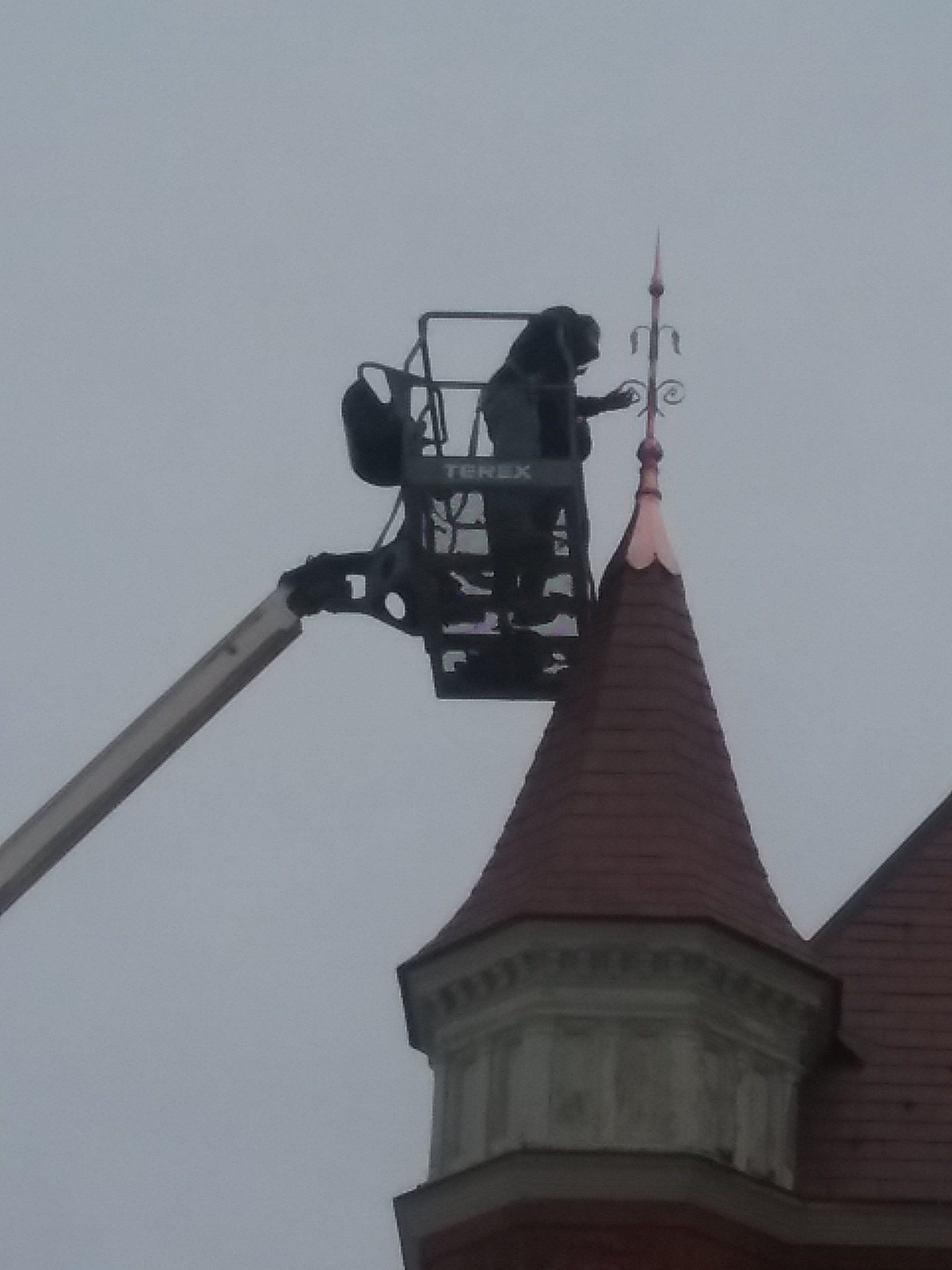 Rodd Roofing employee installing a decorative cap on a high school in Vermont