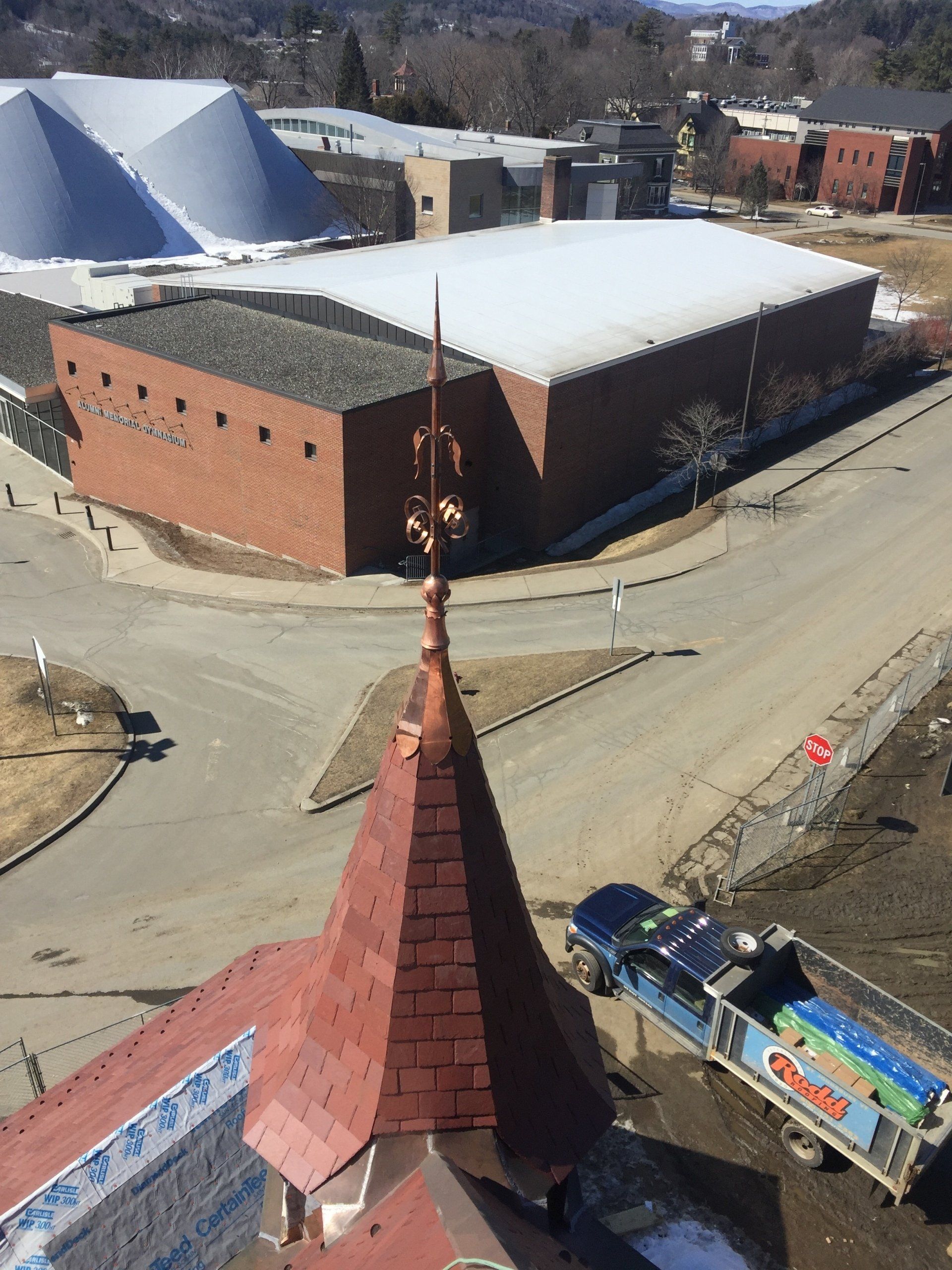 An aerial view of a brick building with a red roof