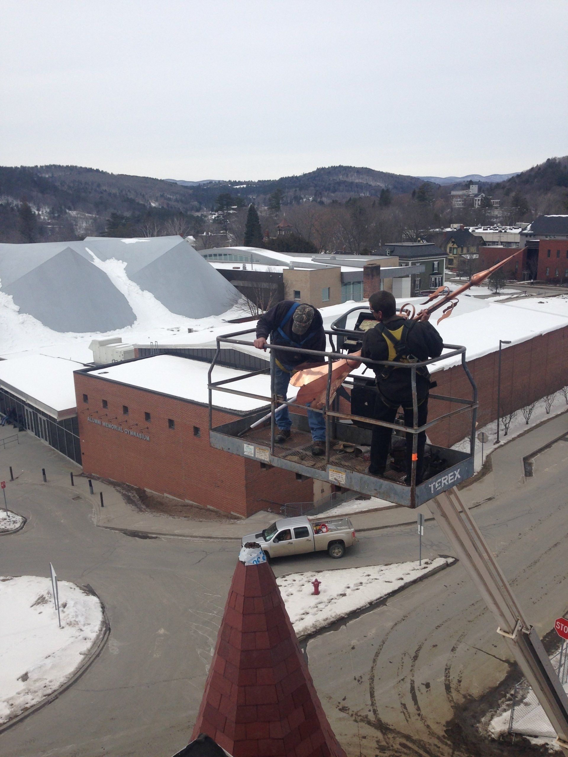 Rodd Roofing employees installing a decorative cap for a high school in Vermont