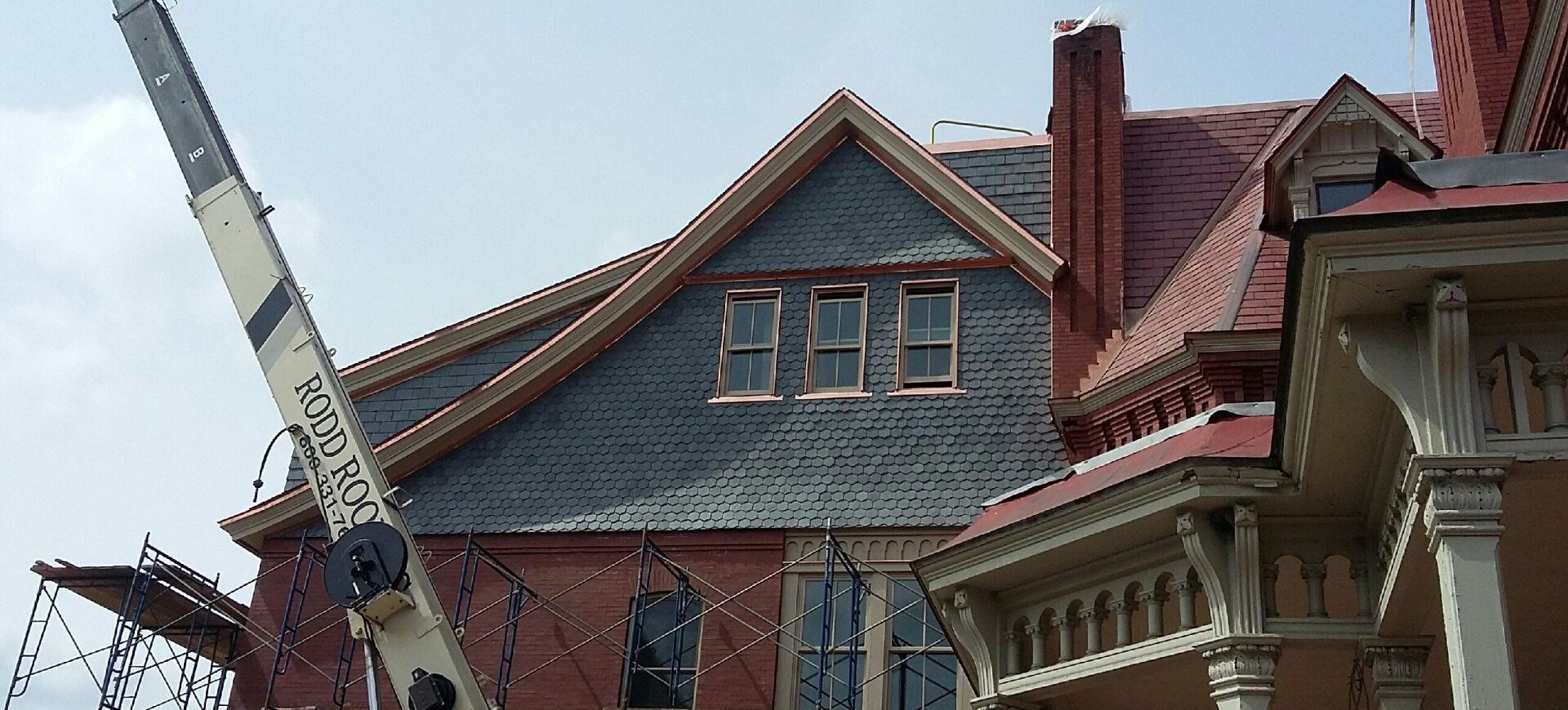 A historical St. Johnsbury, Vermont building undergoing a shingle roof installation by Rodd Roofing