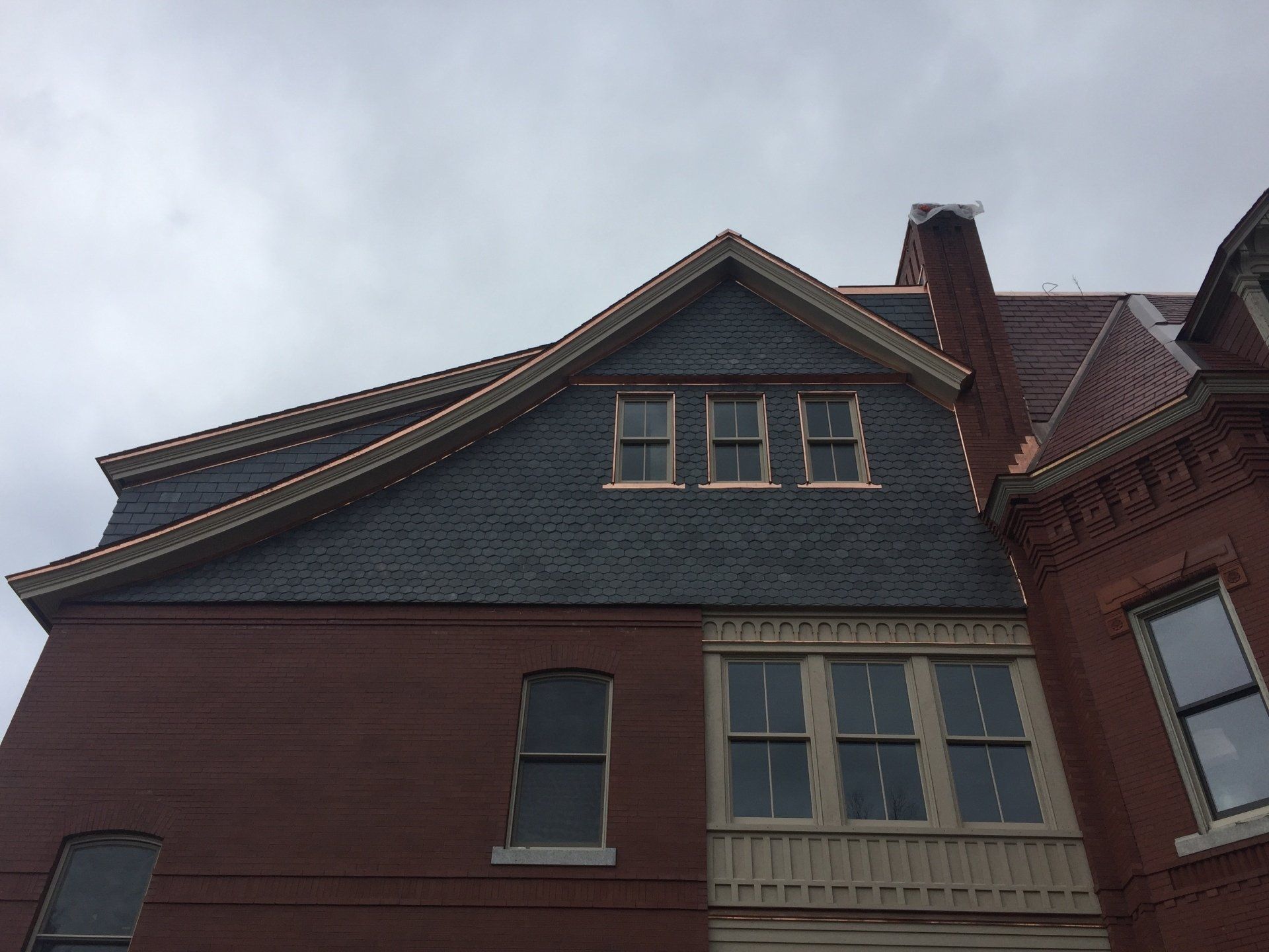 A large brick building with a slate roof and windows