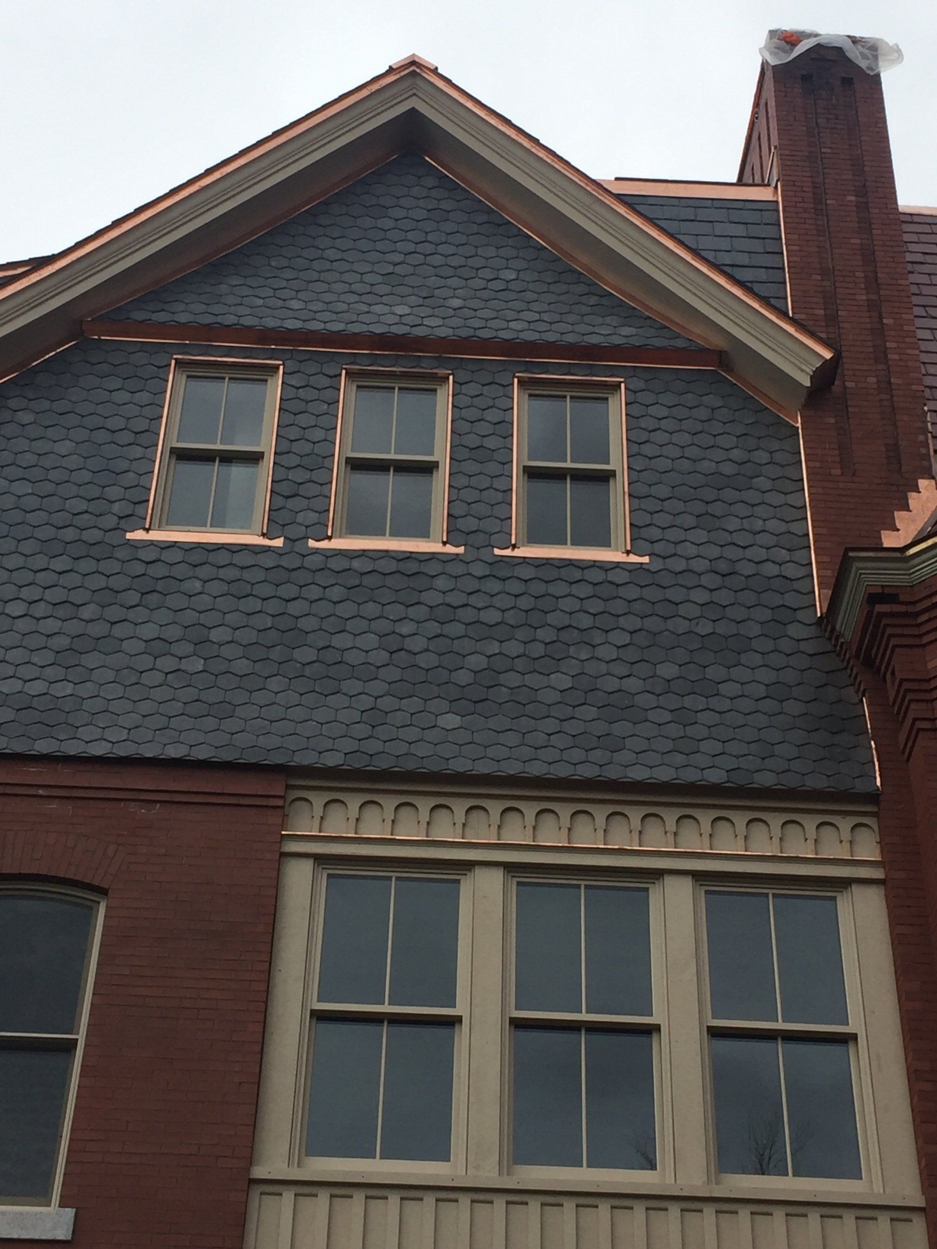A brick building with a slate roof and a chimney