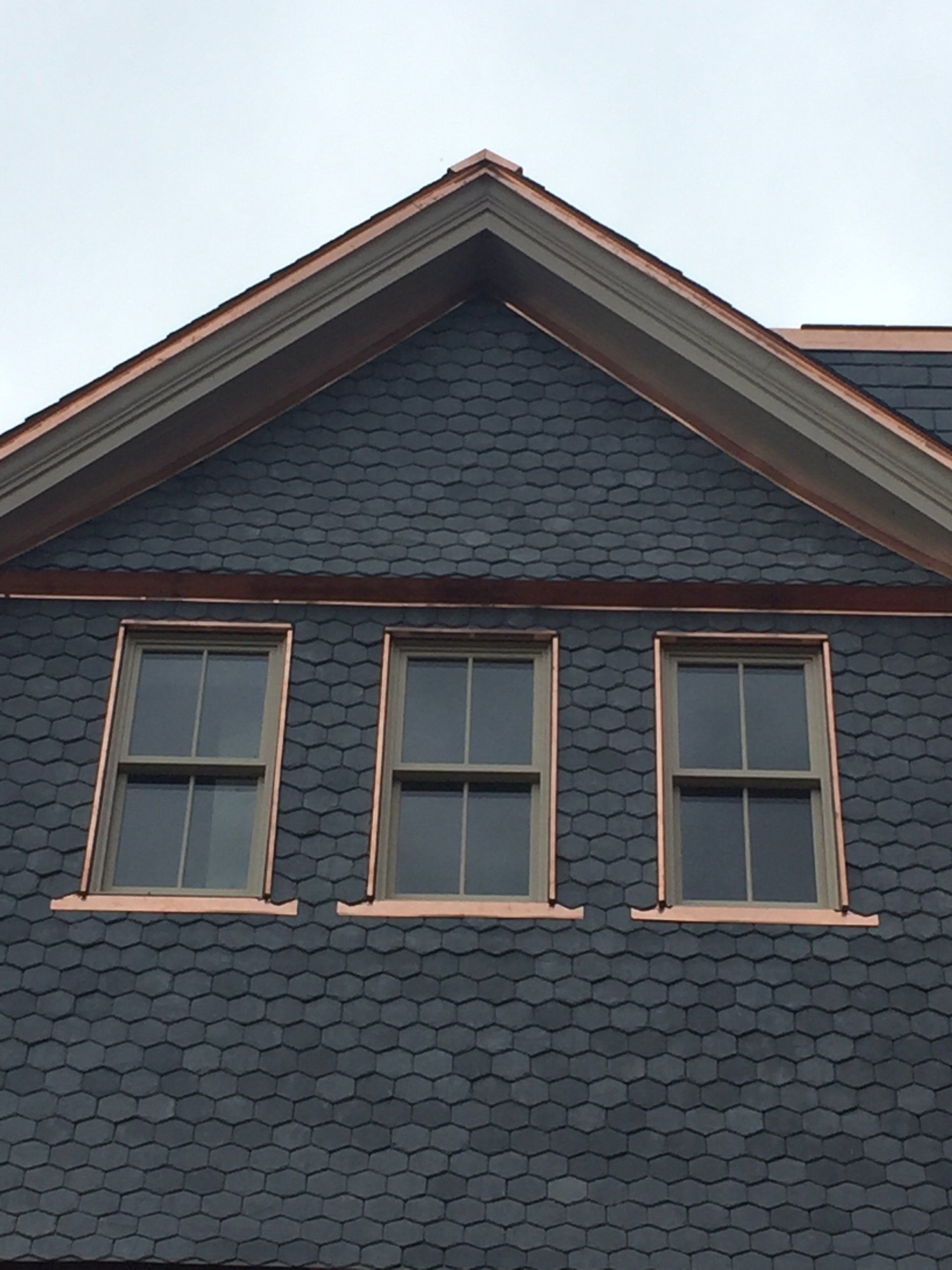 A house with a copper roof and three windows