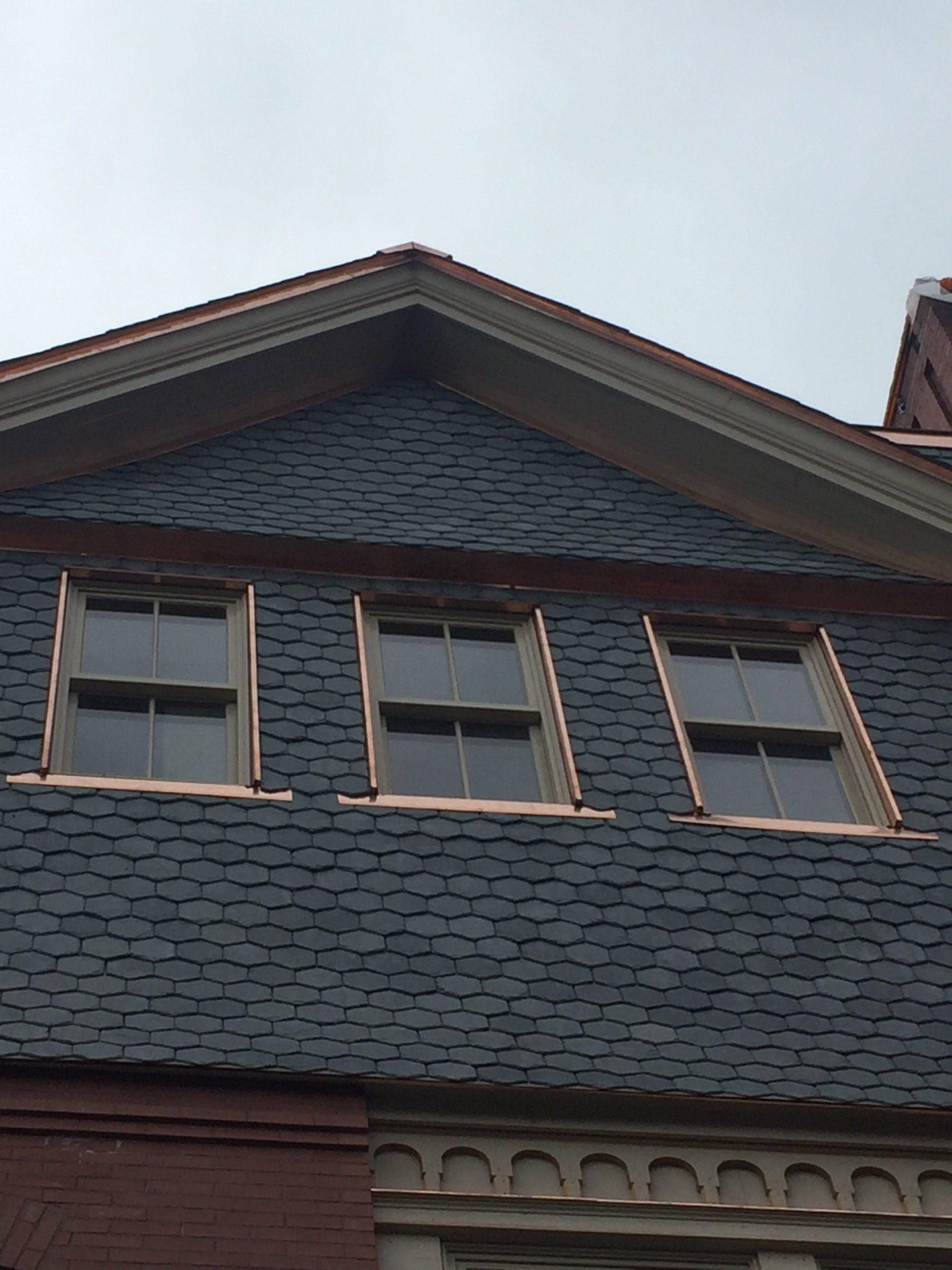 The roof of a building with three windows on it