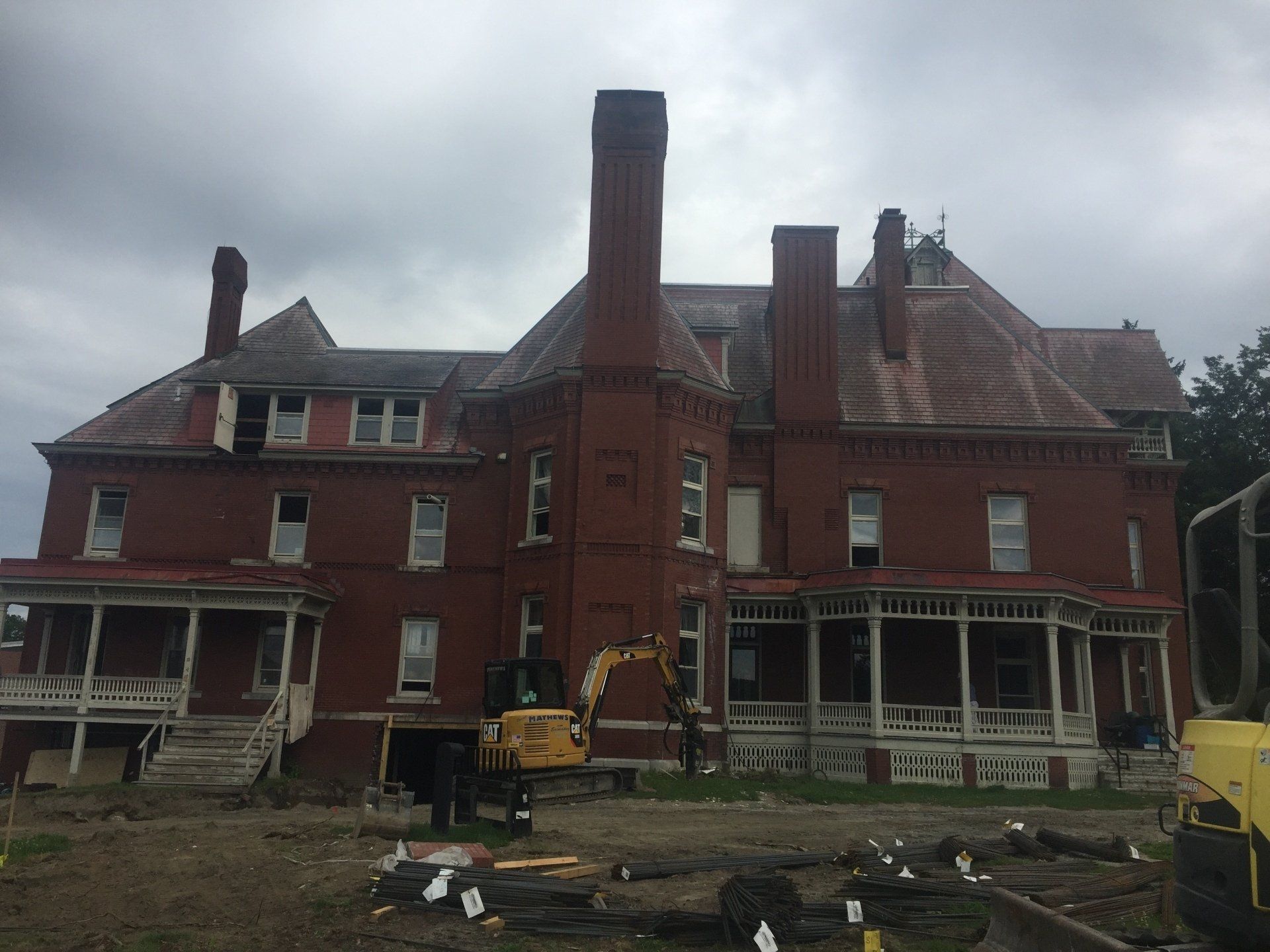 A large brick house with a large chimney is being demolished.
