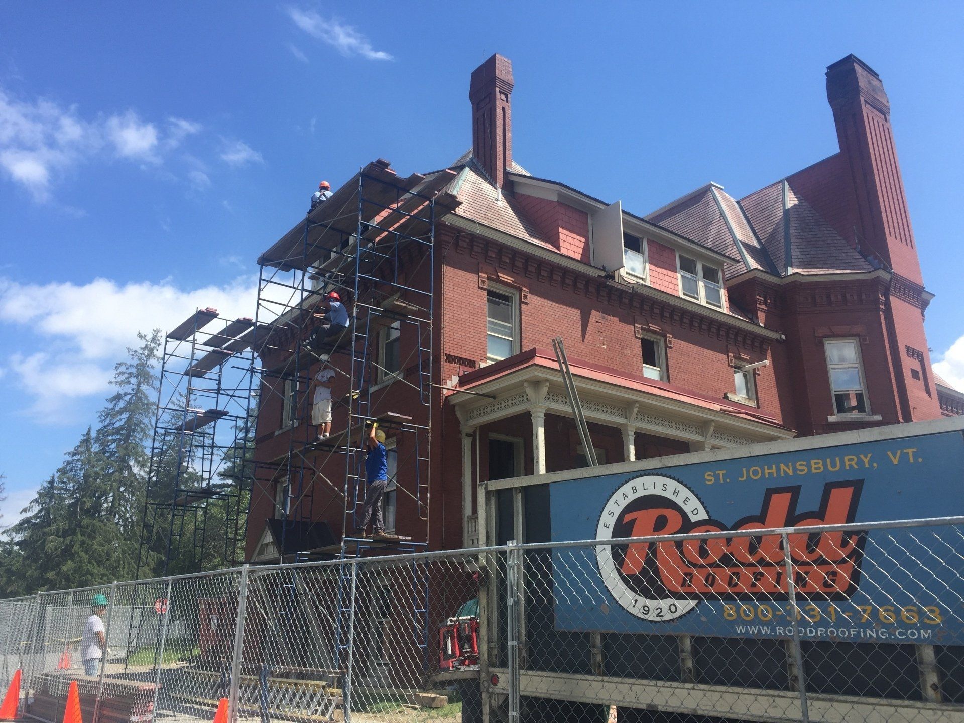 A large red brick building with scaffolding around it and a sign that says roddy construction