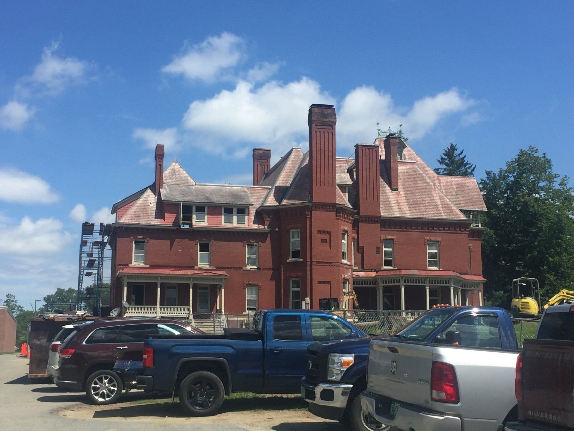 A large brick building with a lot of cars parked in front of it