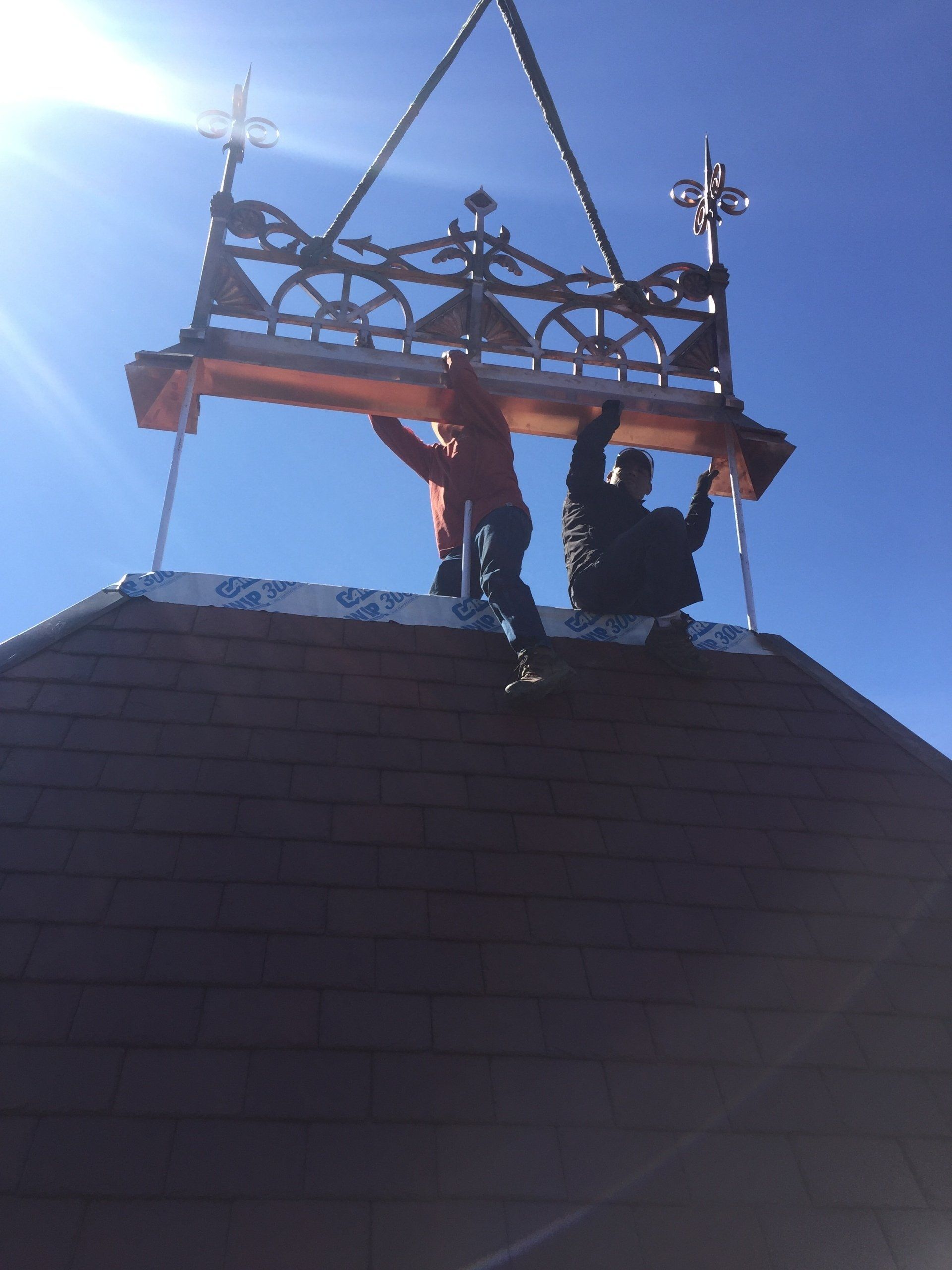 Two men are working on the roof of a building