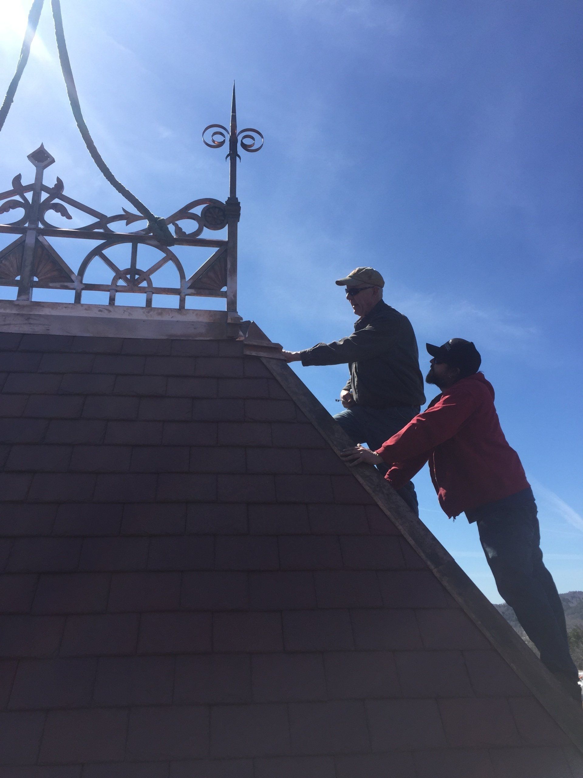 Two men are working on the roof of a building