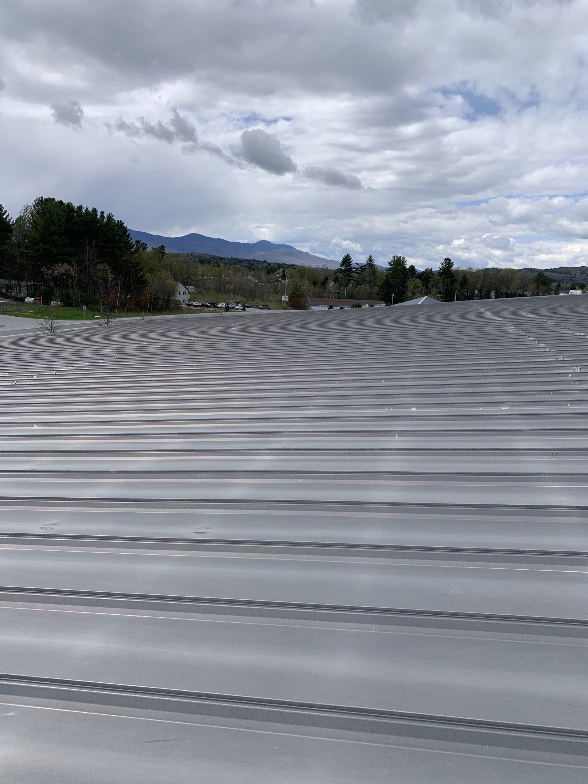 A large gray roof with mountains in the background