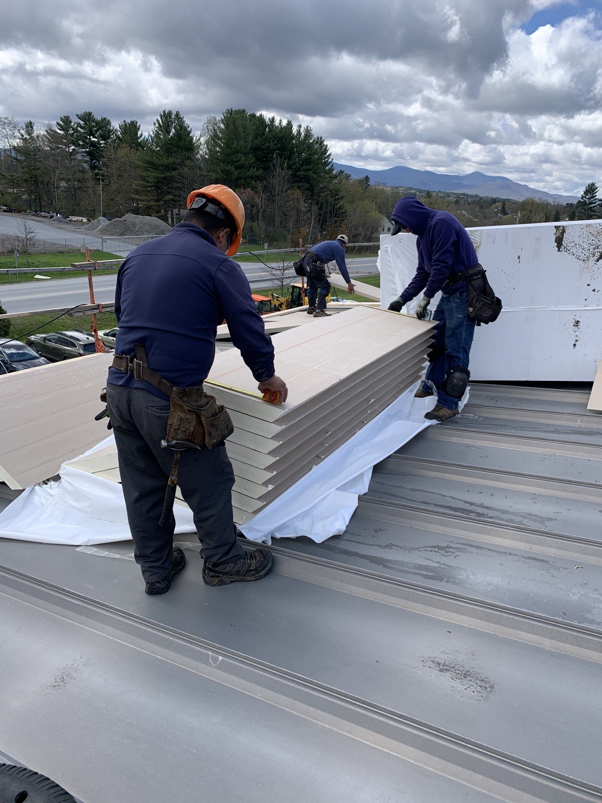 A group of men are working on a roof.