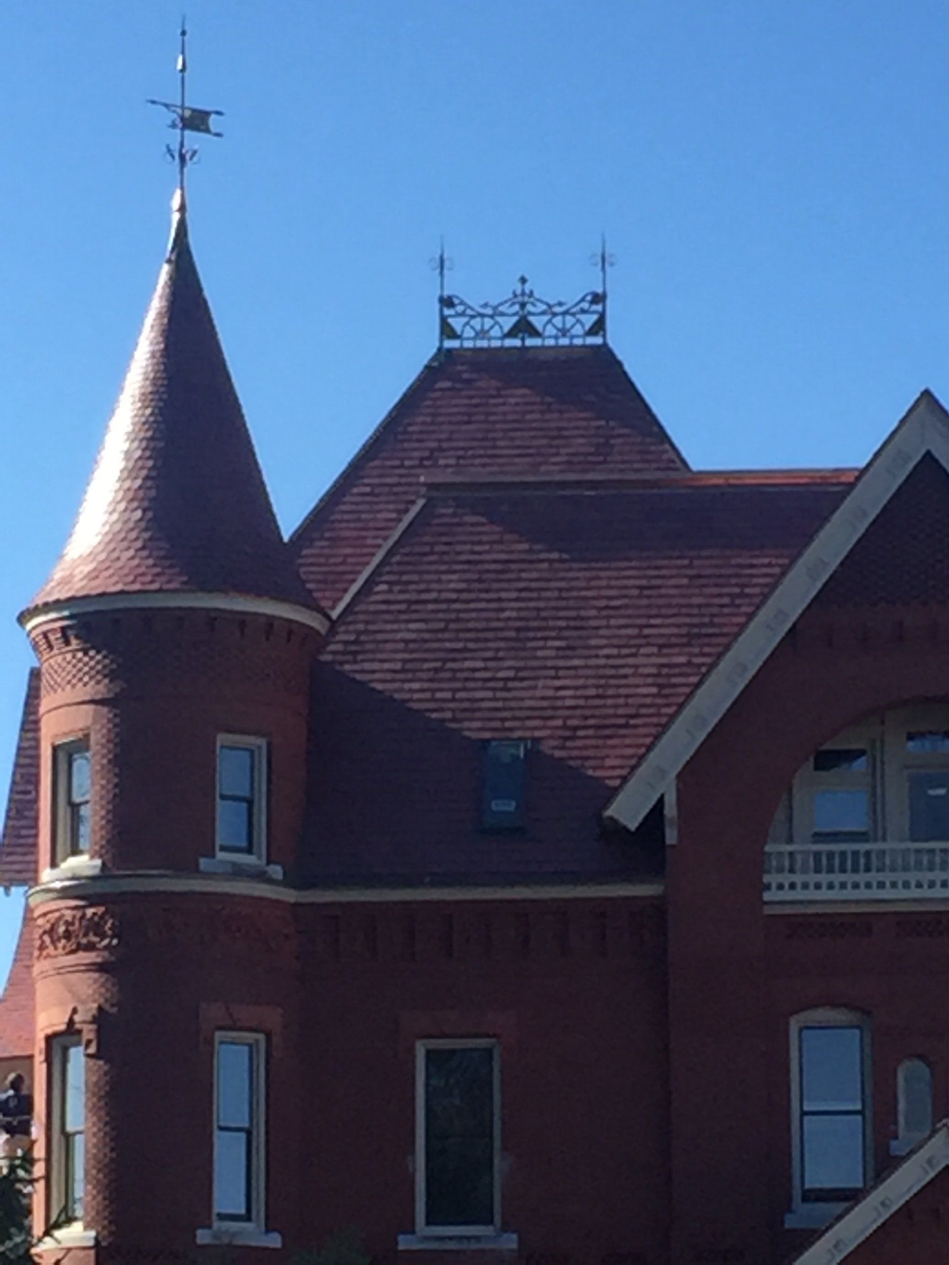 A brick building with a weather vane on top of it