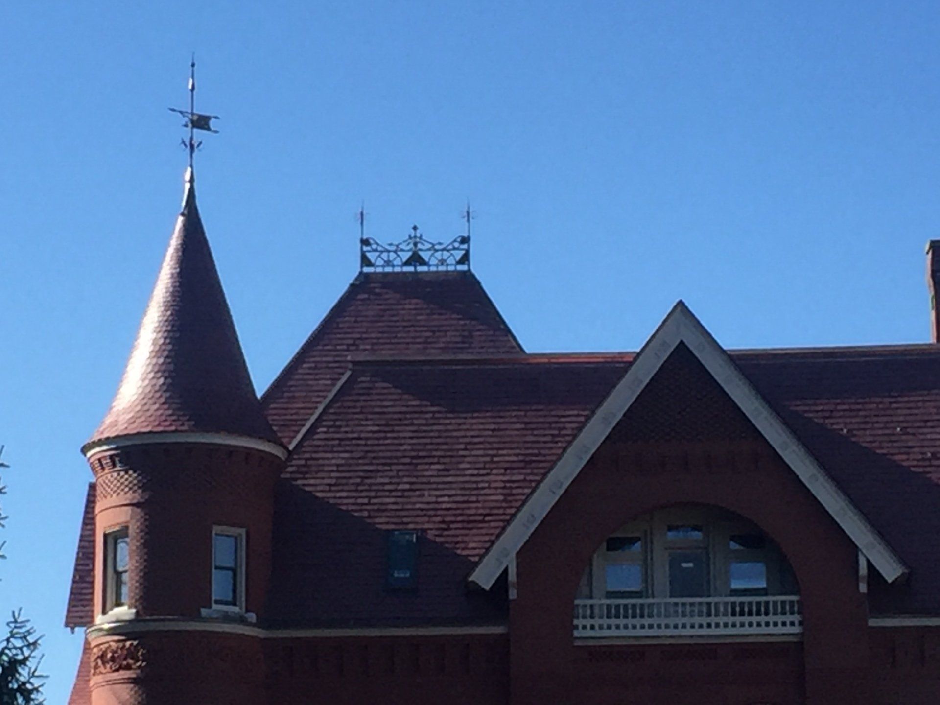 A brick building with a weather vane on top of it