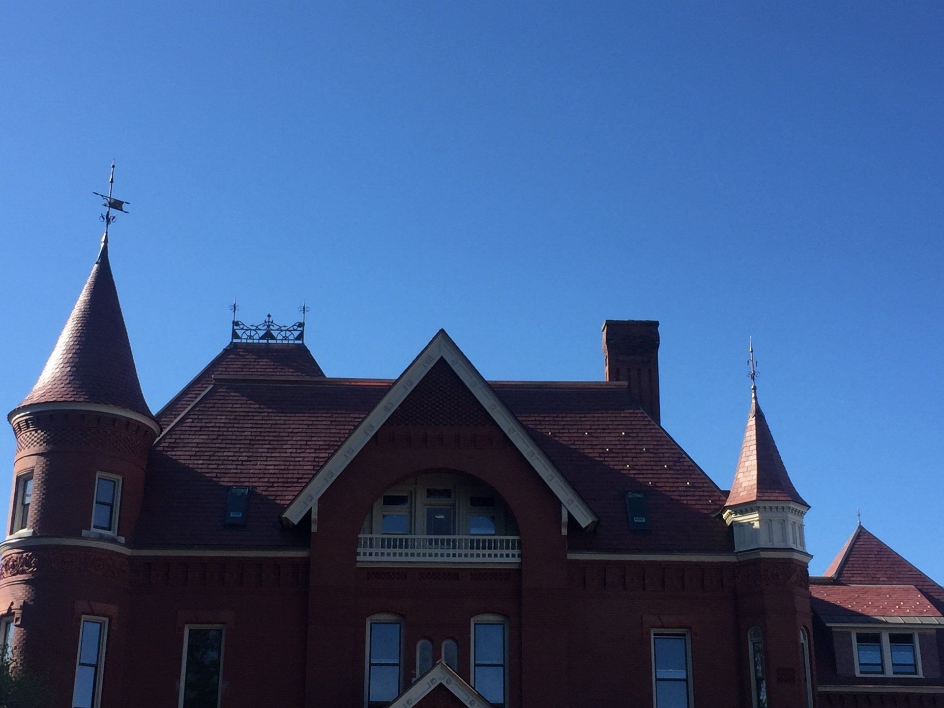 A large brick building with a weather vane on top of it