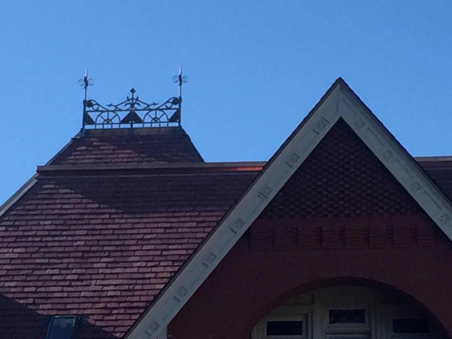 A brick building with a weather vane on top of it