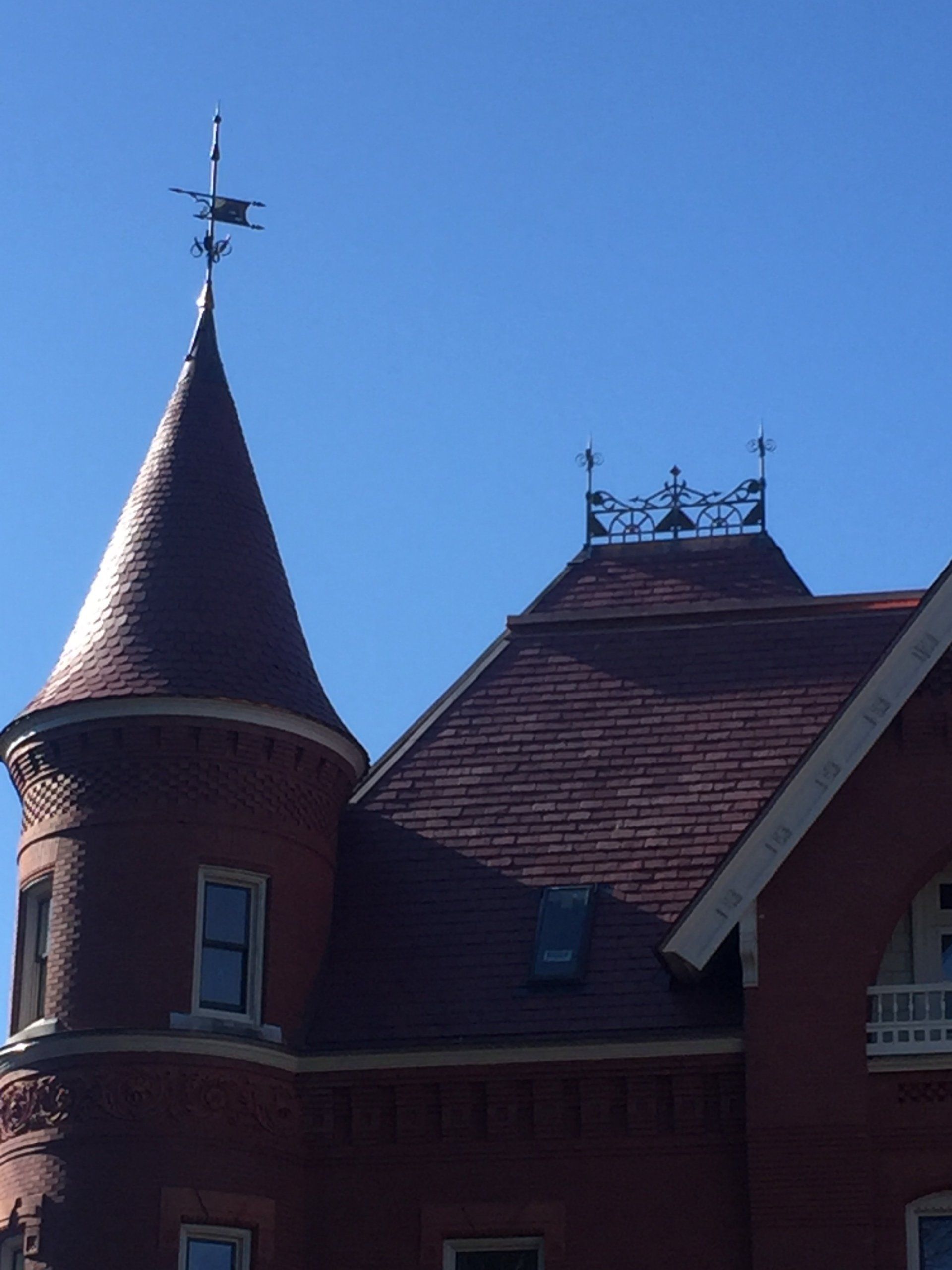 A brick building with a weather vane on top of it