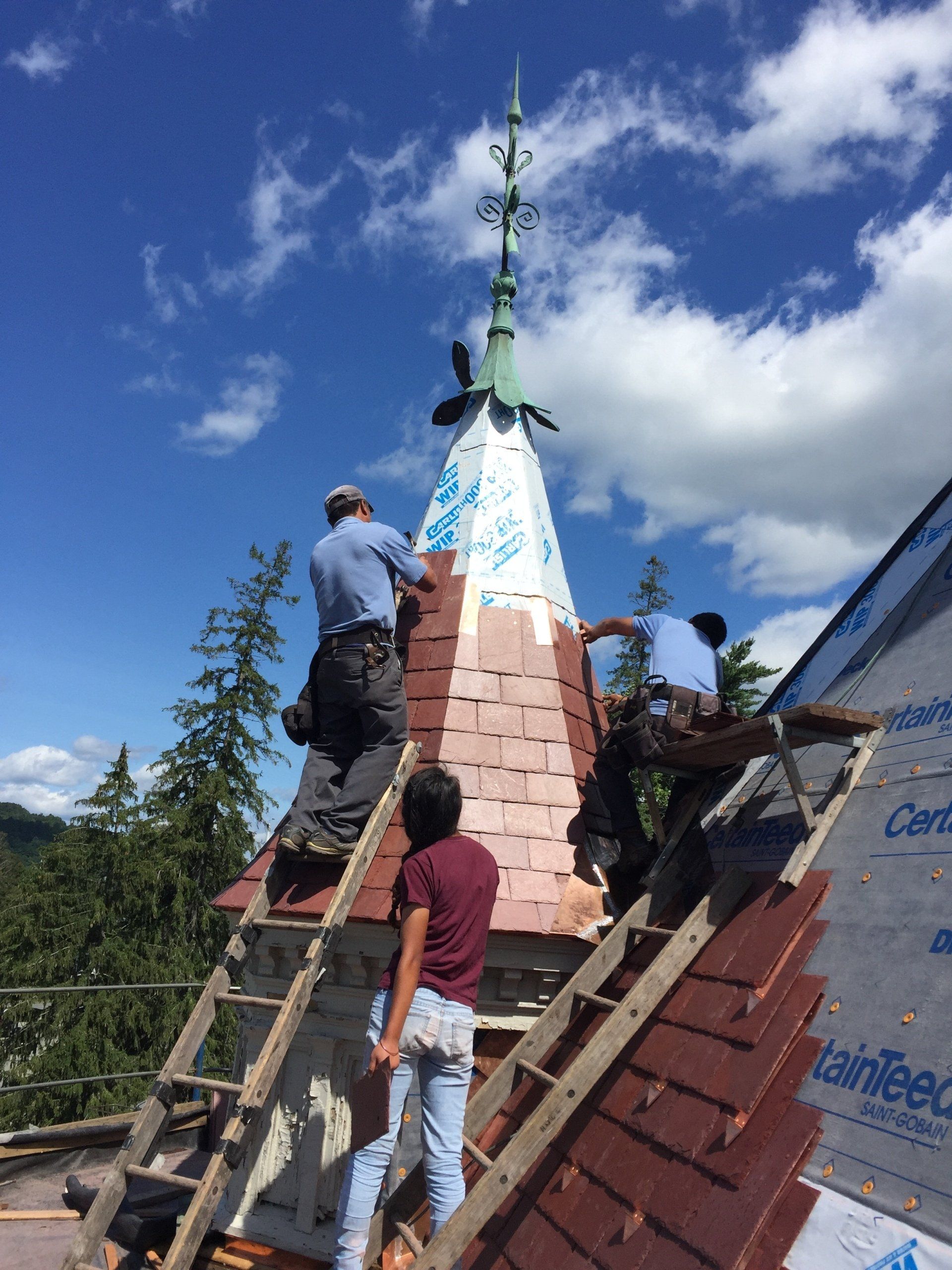A group of people are working on the roof of a building.