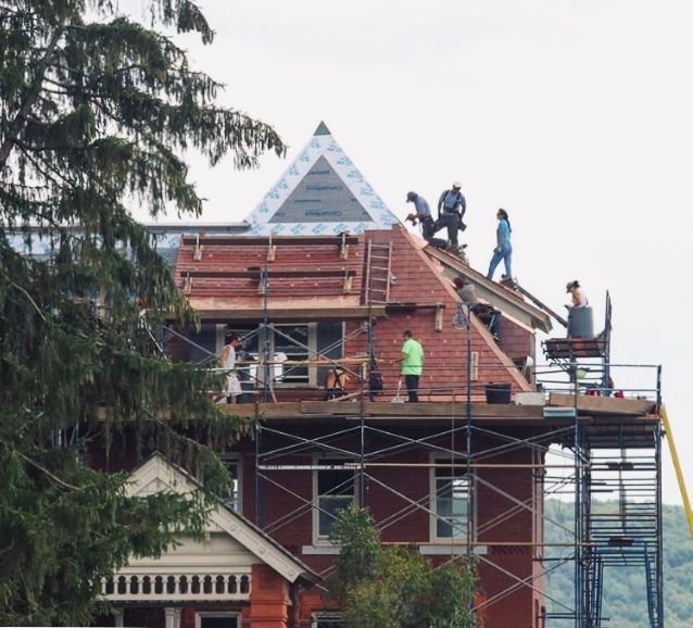 A group of people are working on the roof of a building