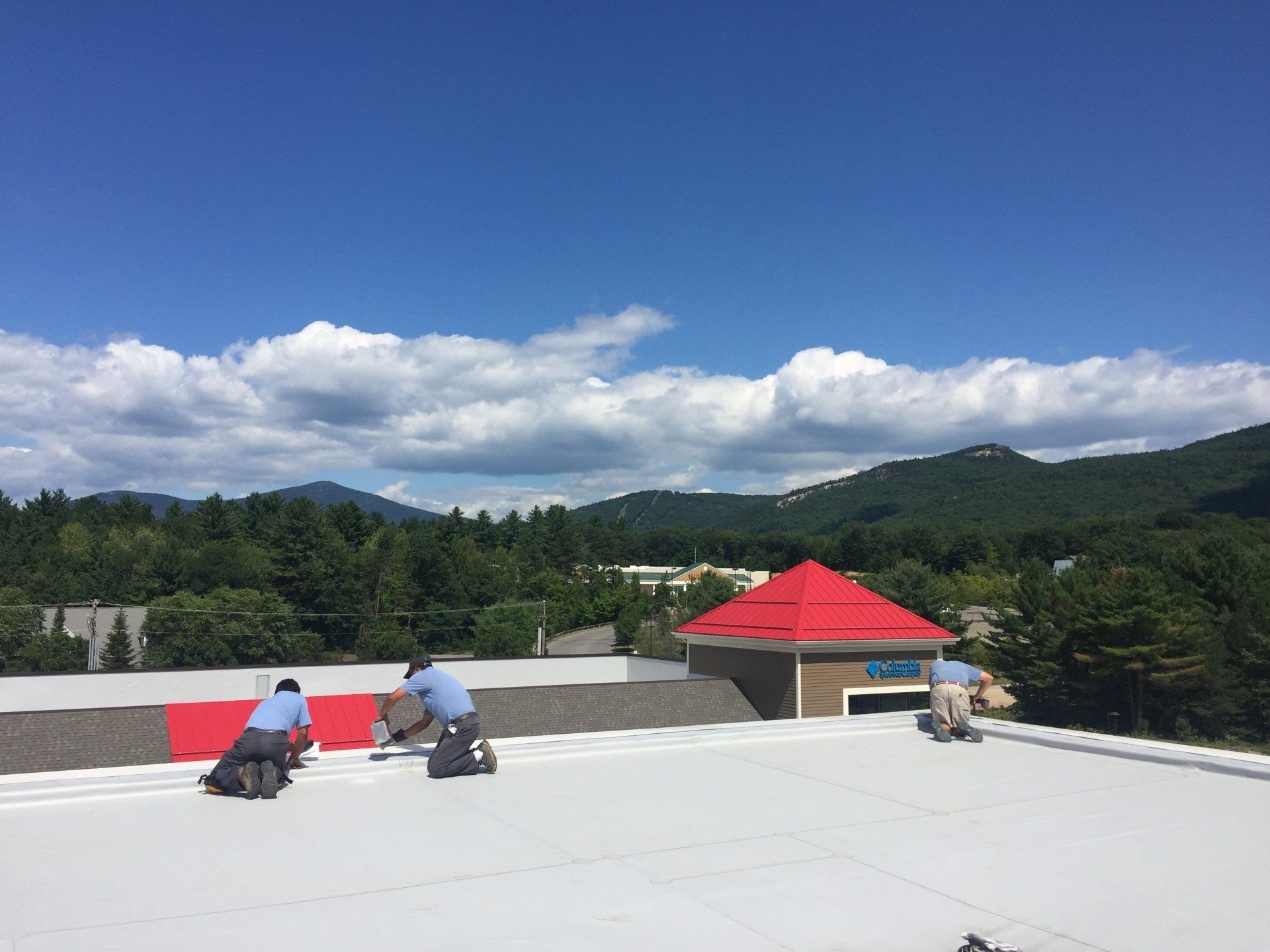 A group of people are working on the roof of a building.