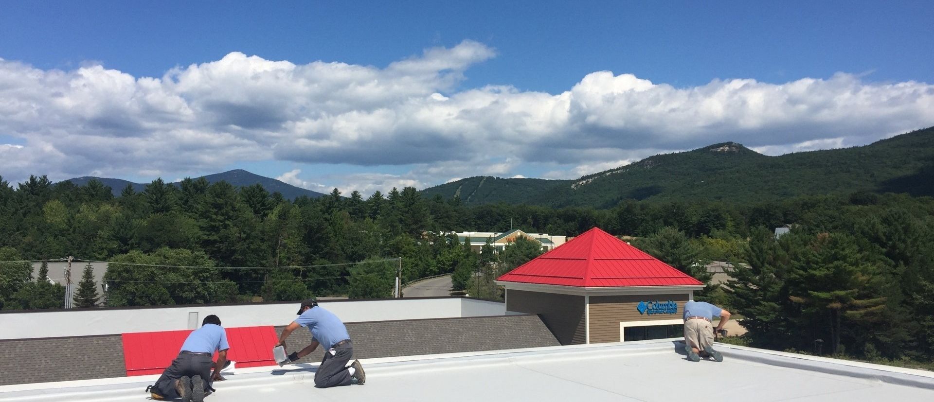 Rodd Roofing employees apply coating to a New Hampshire commercial roof