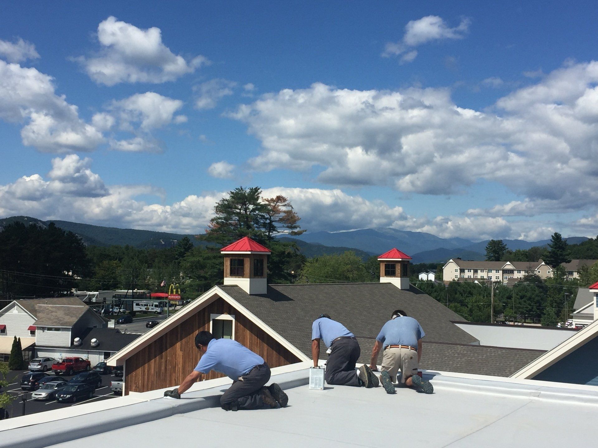 Three men are working on the roof of a building