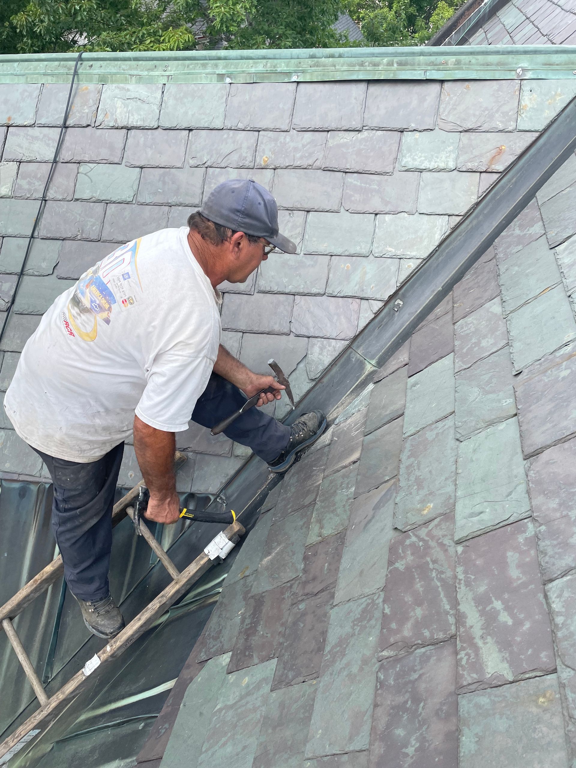 Brian Aldrich working alone on slate shingled roof