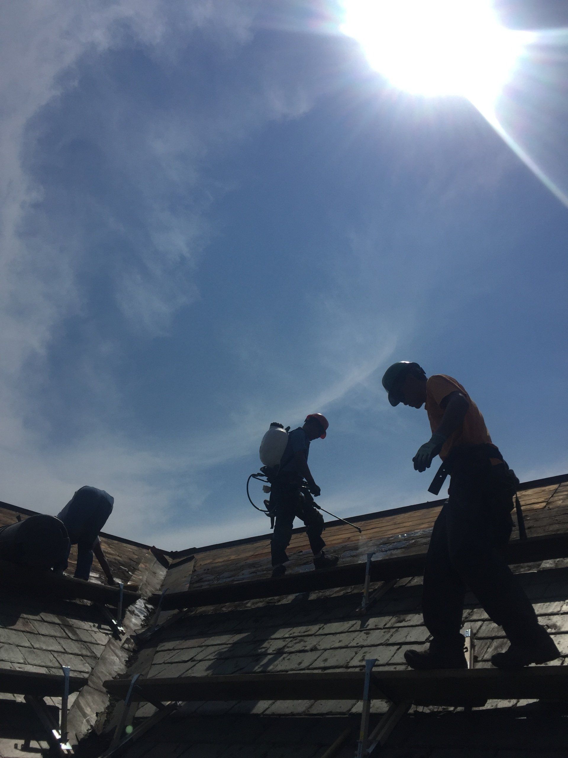 Rodd roofing employees installing a wooden underlayment