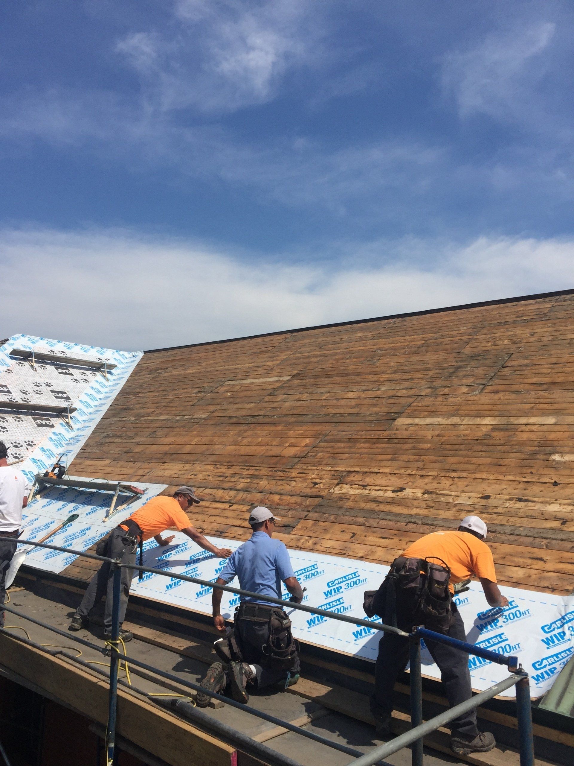 Rodd Roofing employees installing a wooden underlayment