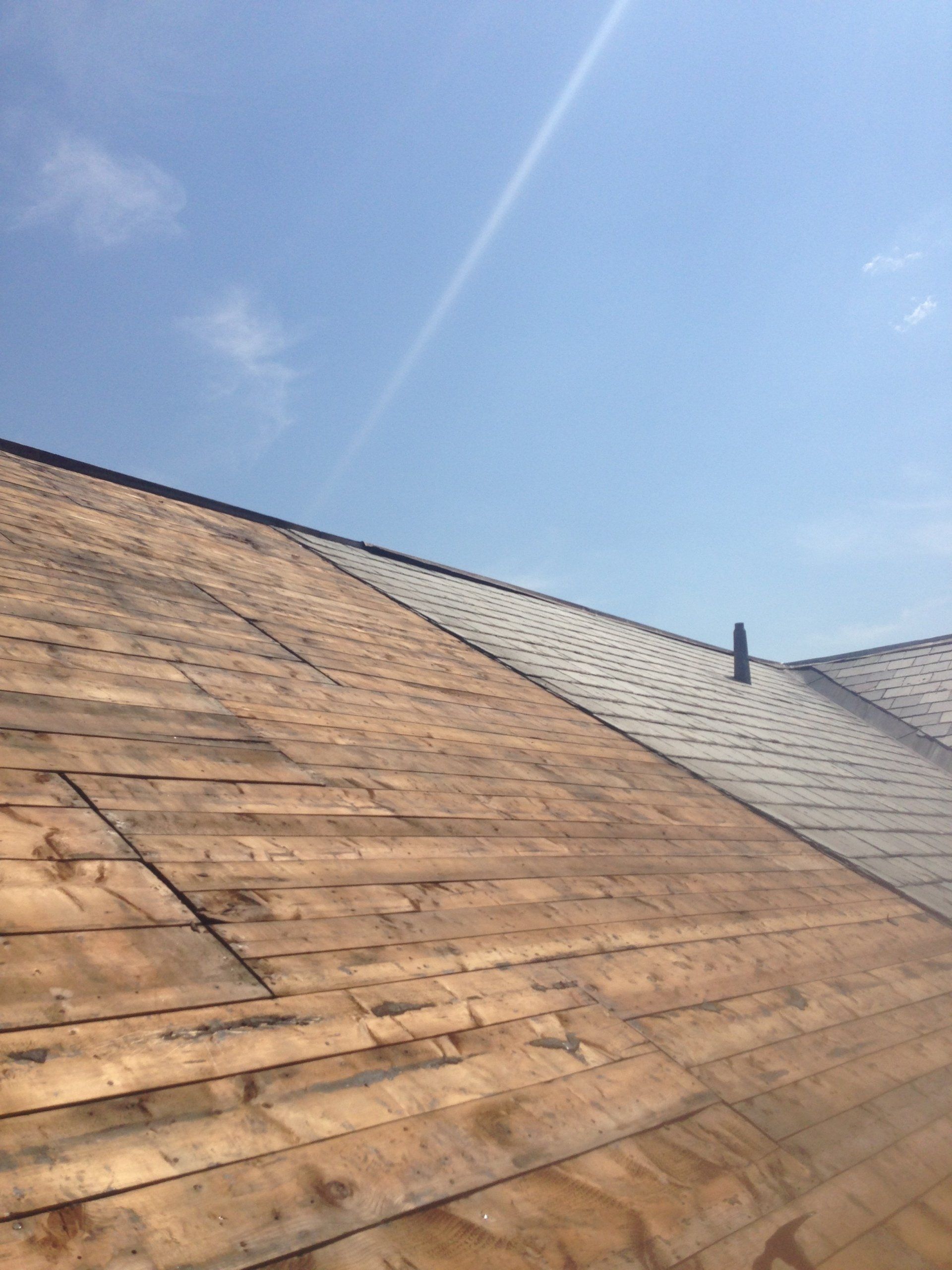 A wooden roof with a blue sky in the background.